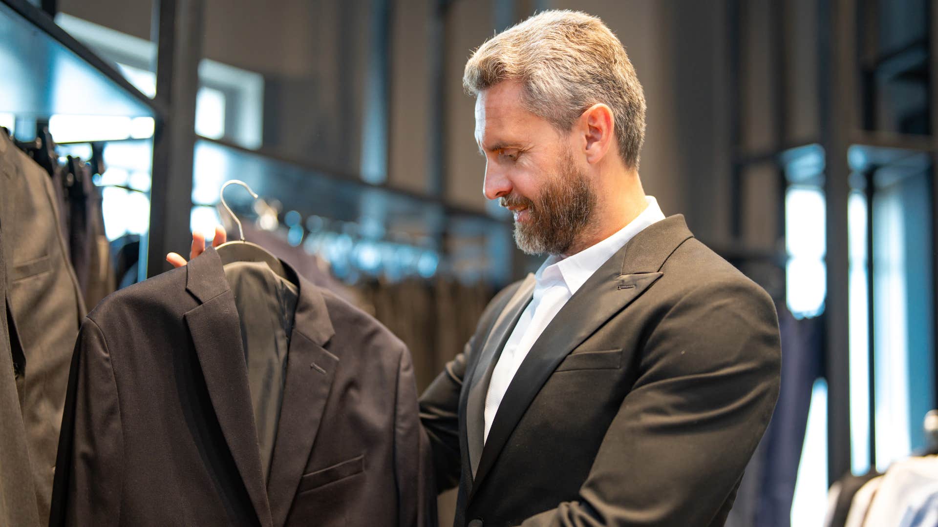 man dressing for himself looking at suits