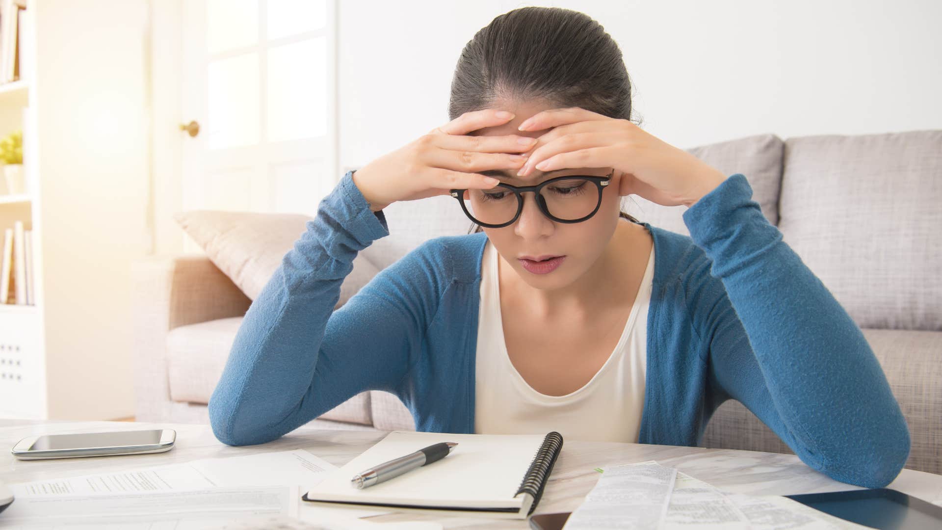Woman doing bills and fearing credit cards.