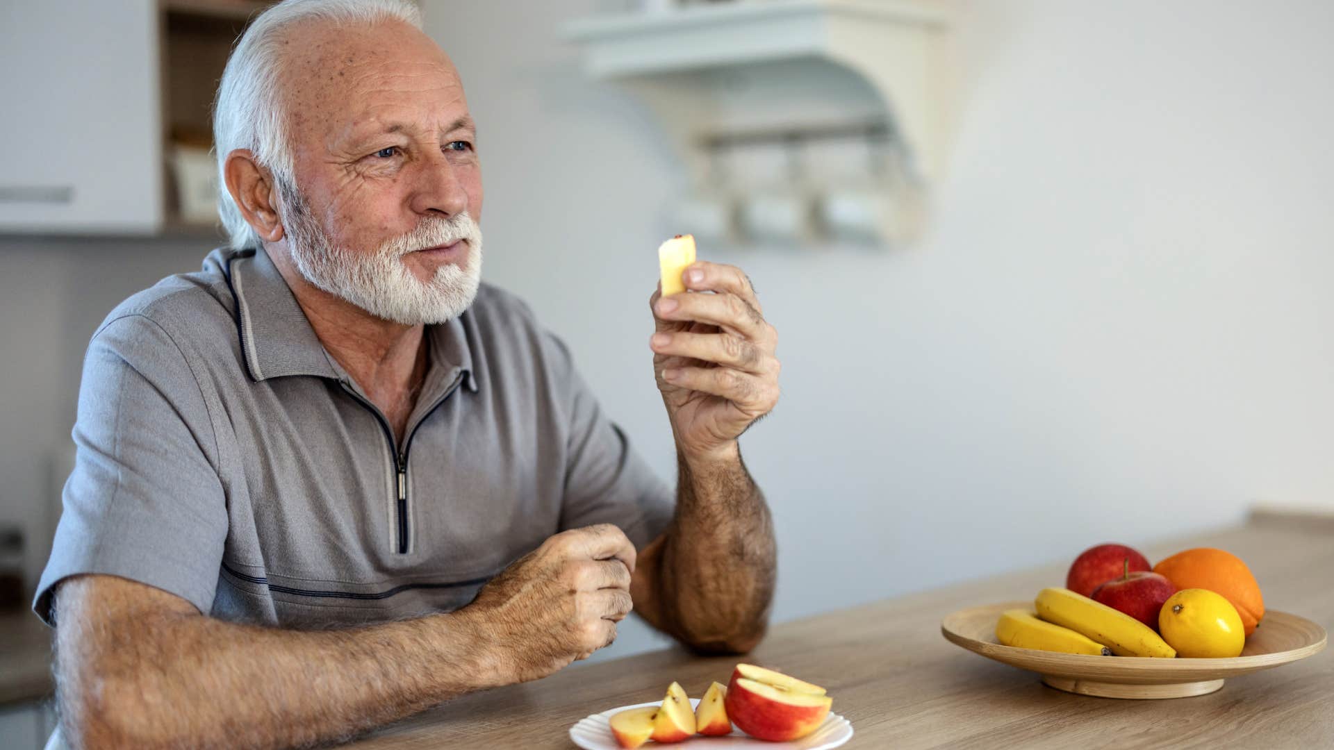 frugal man who doesn't buy items of convenience eating an apple