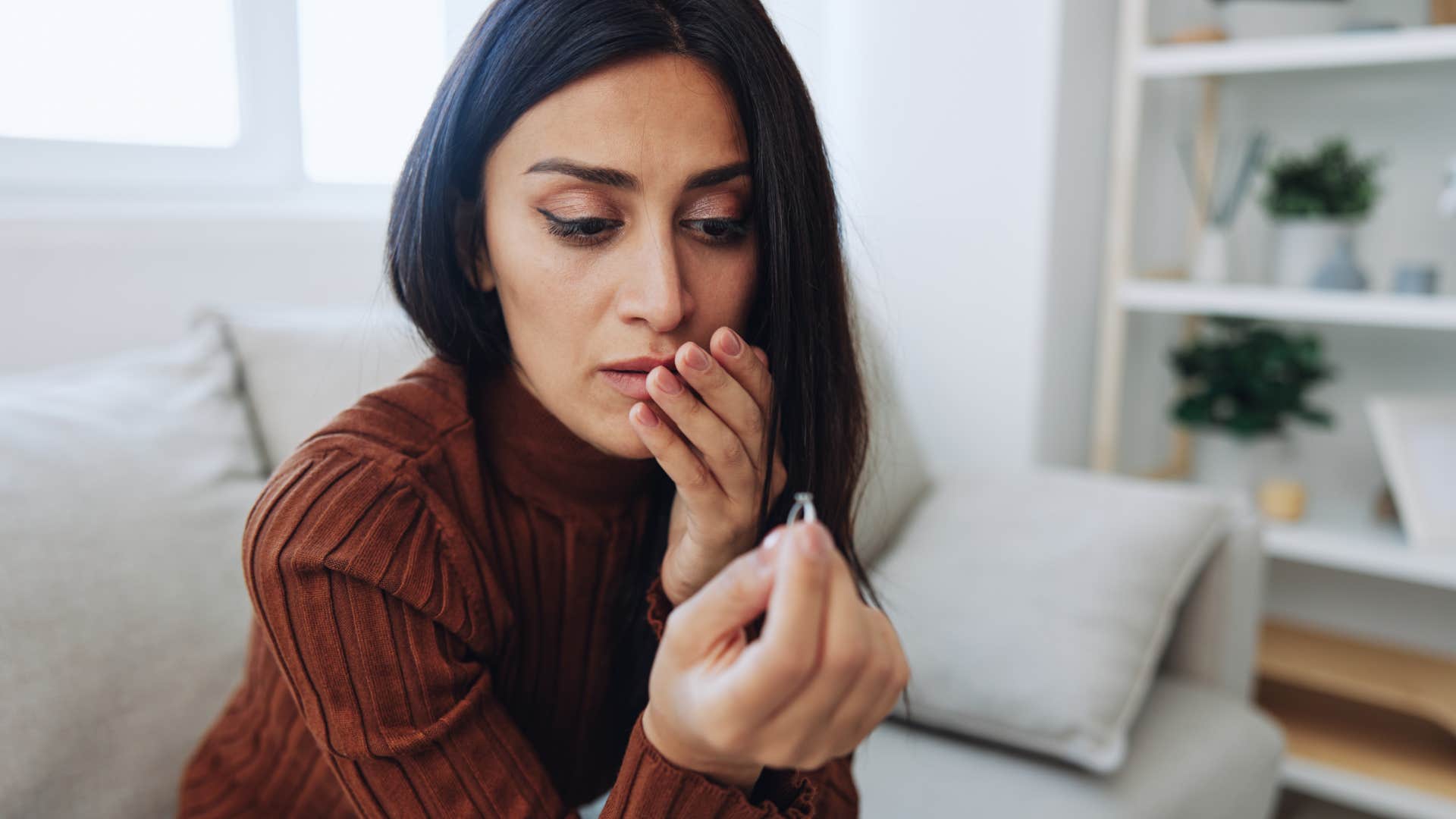 woman looking at engagement ring feeling sick about marriage