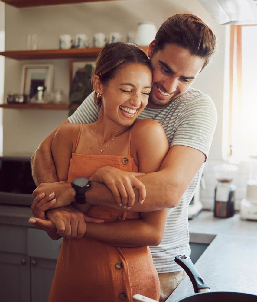 Man hugs woman.