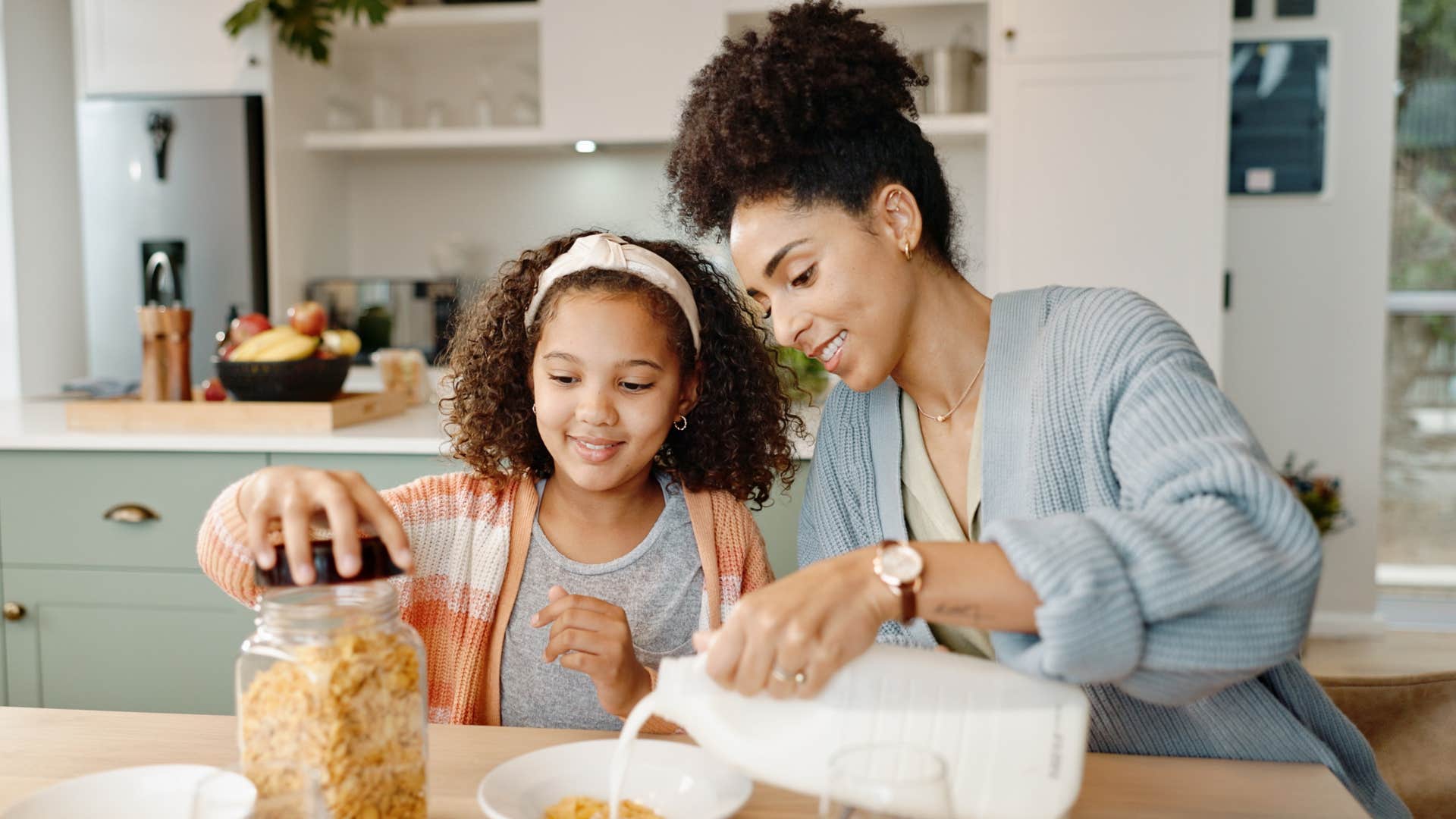 middle class mother and daughter eating cereal for dinner