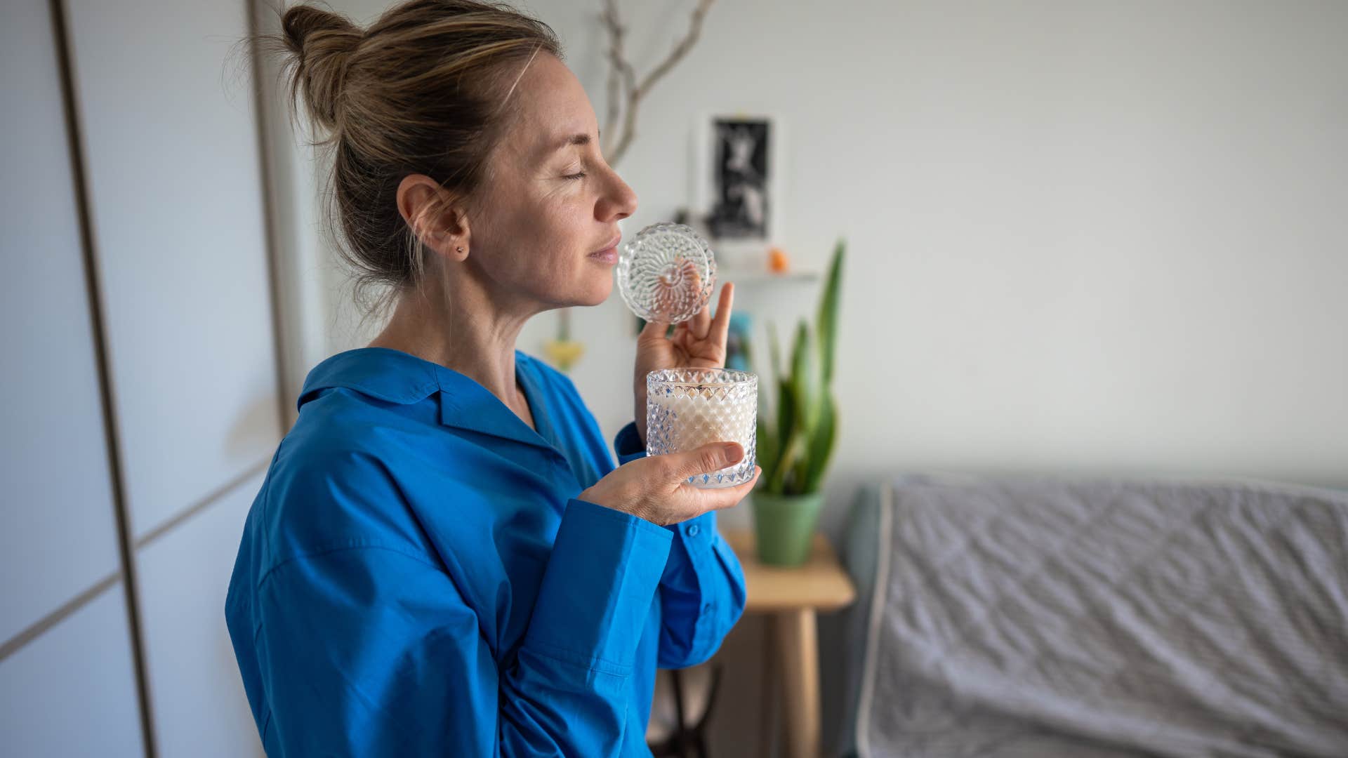 woman smelling grocery store candles at home