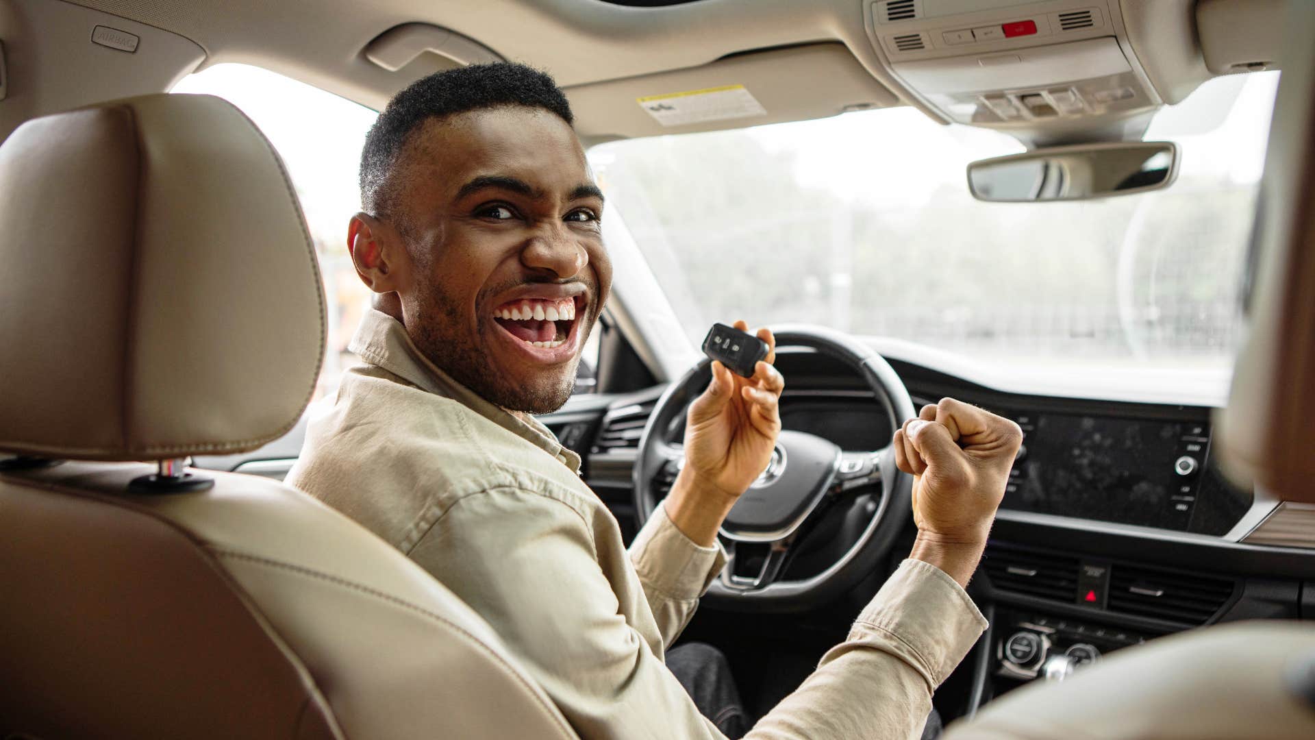 man celebrating small successes in his car