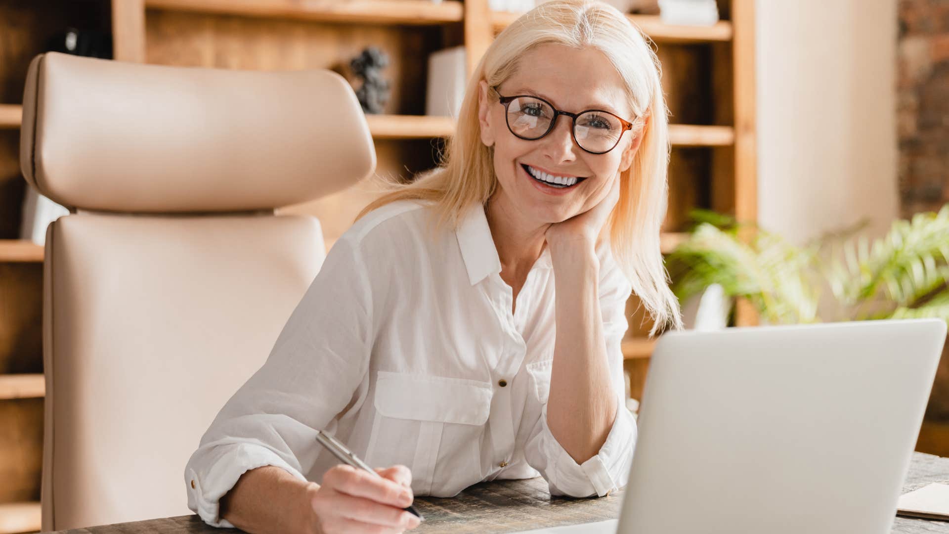 wealthy woman smiling and investing on her computer