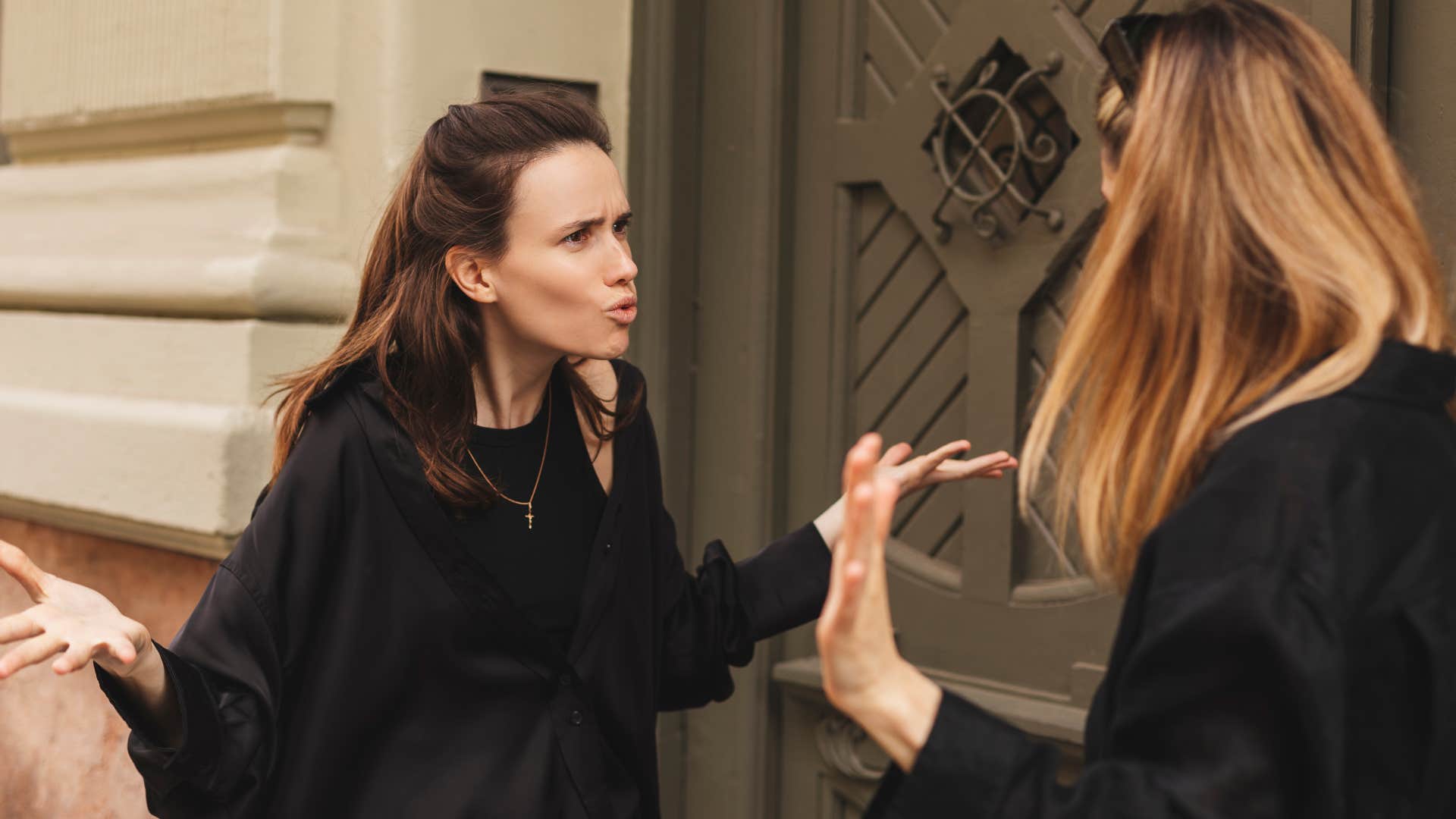 woman in black arguing to win as friend looks perplexed