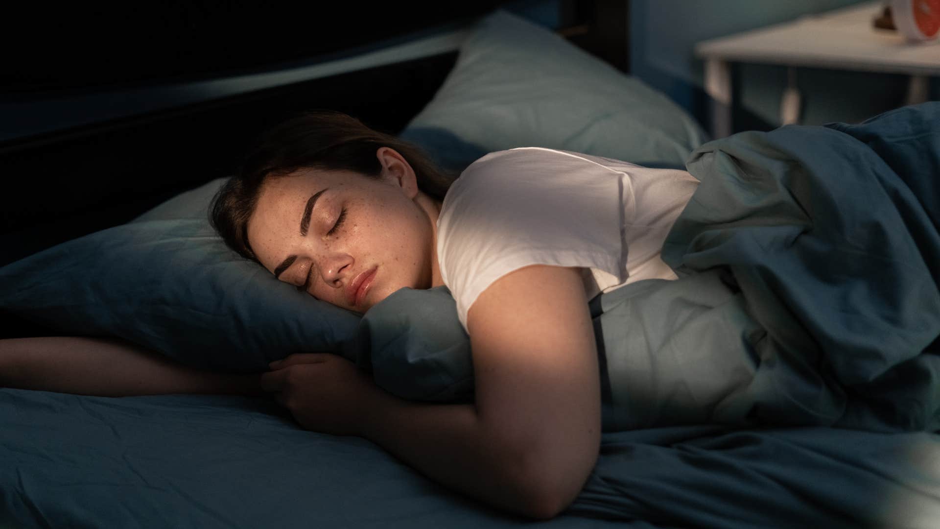 unhappy woman laying in a dark room with blackout curtains