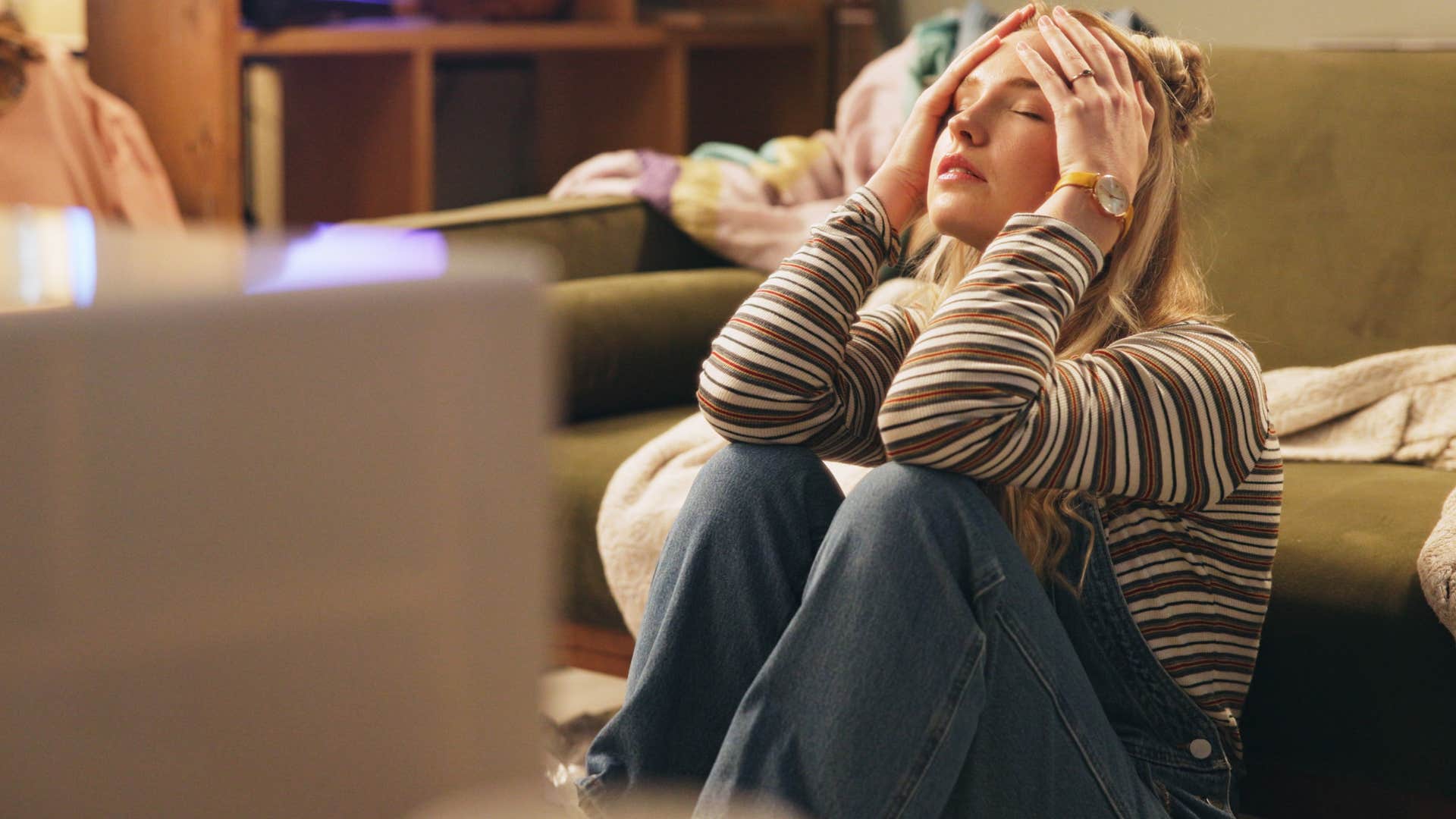 sad woman surrounded by clothes she will never wear