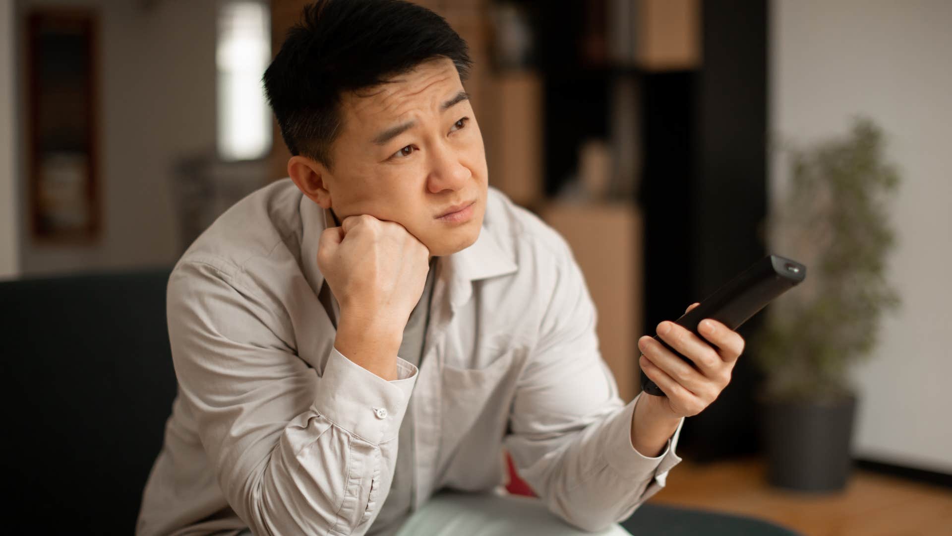 unhappy man with too many streaming services watching TV