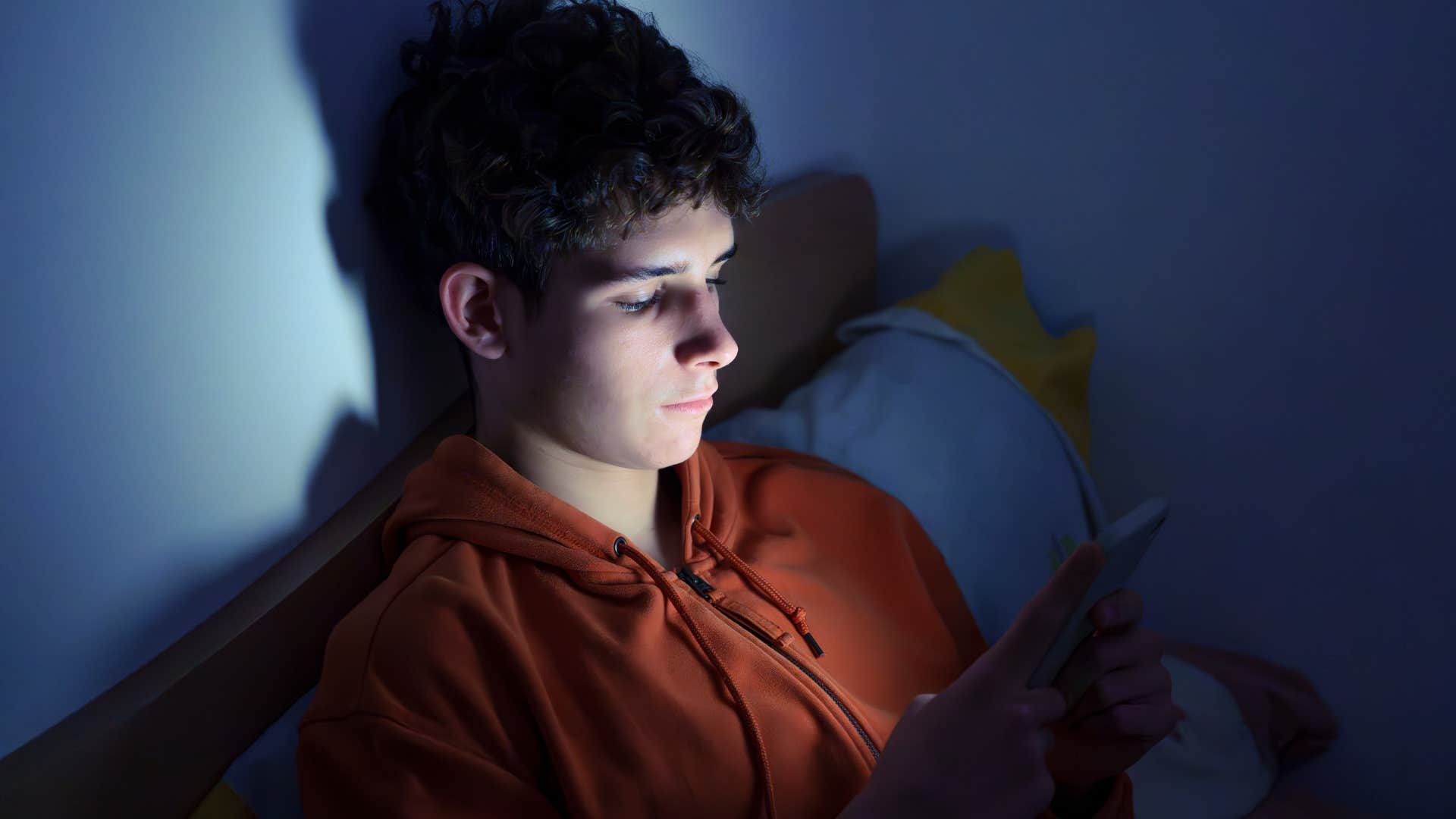 man with too many screens around him scrolling his phone