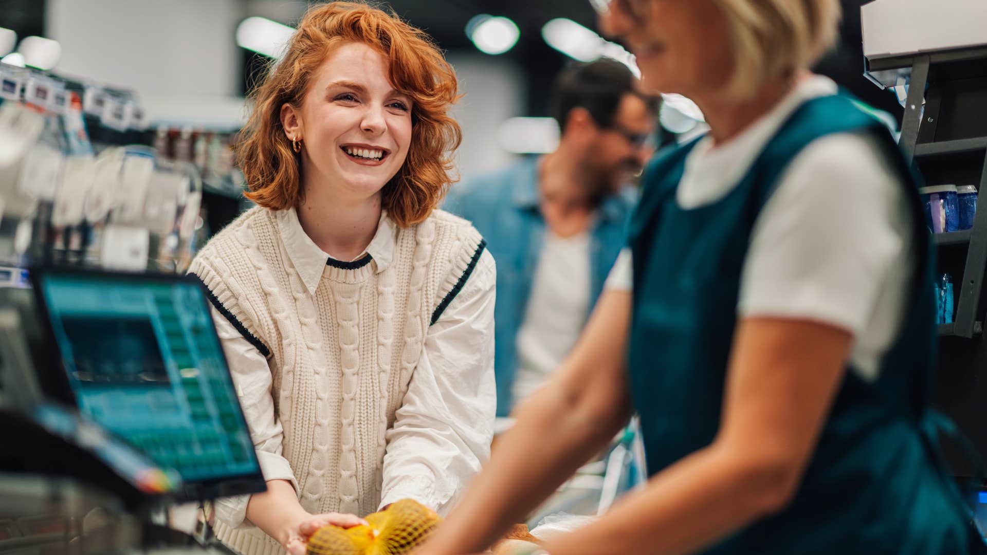 Woman paying with cash at the grocery store.