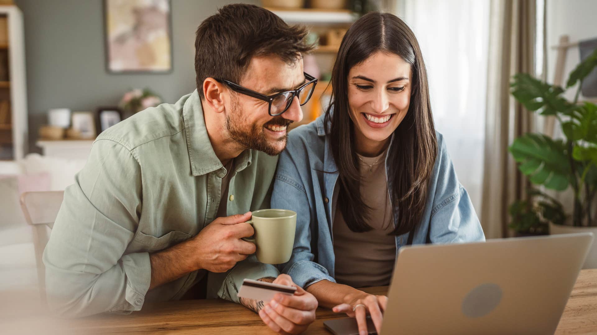 Couple smiling and shopping online at home.