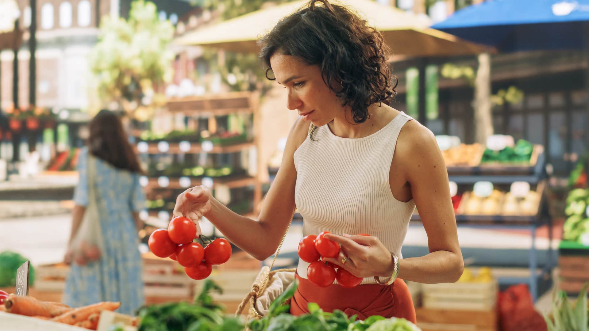 Woman buying whole produce at a farmer's market.