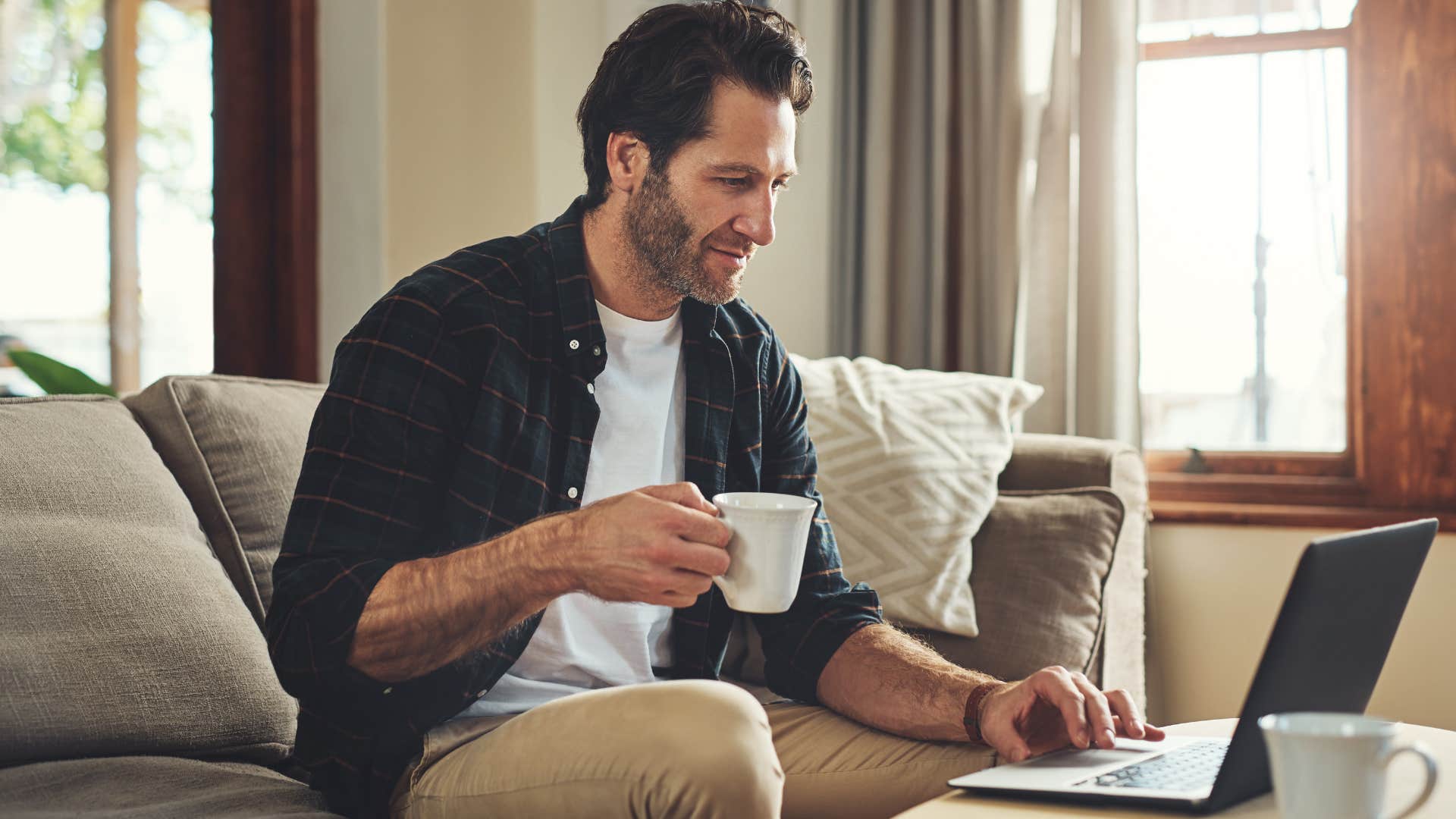 frugal man reviewing his budget sitting on the couch