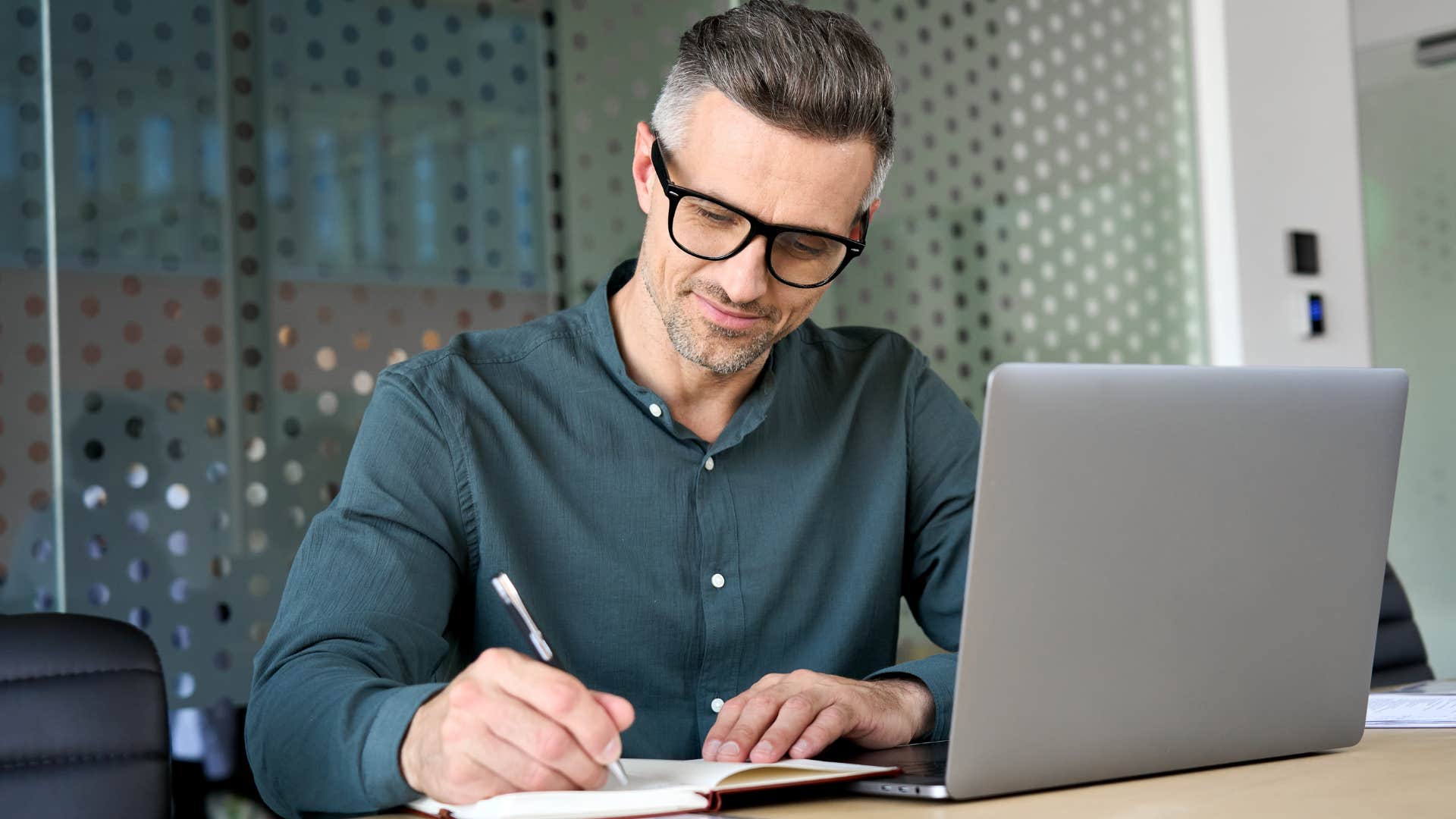 man making a to-do list in a notebook