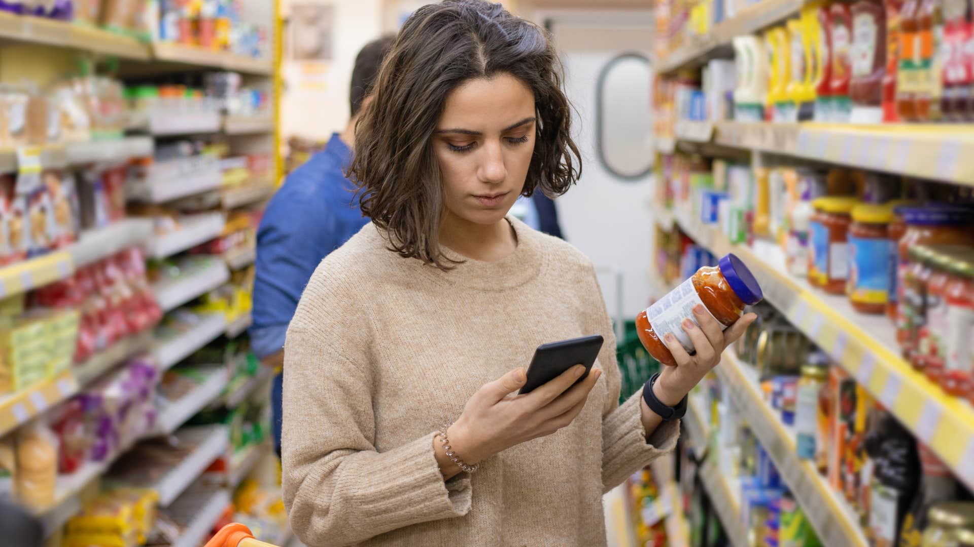 woman choosing cheaper options in the grocery store