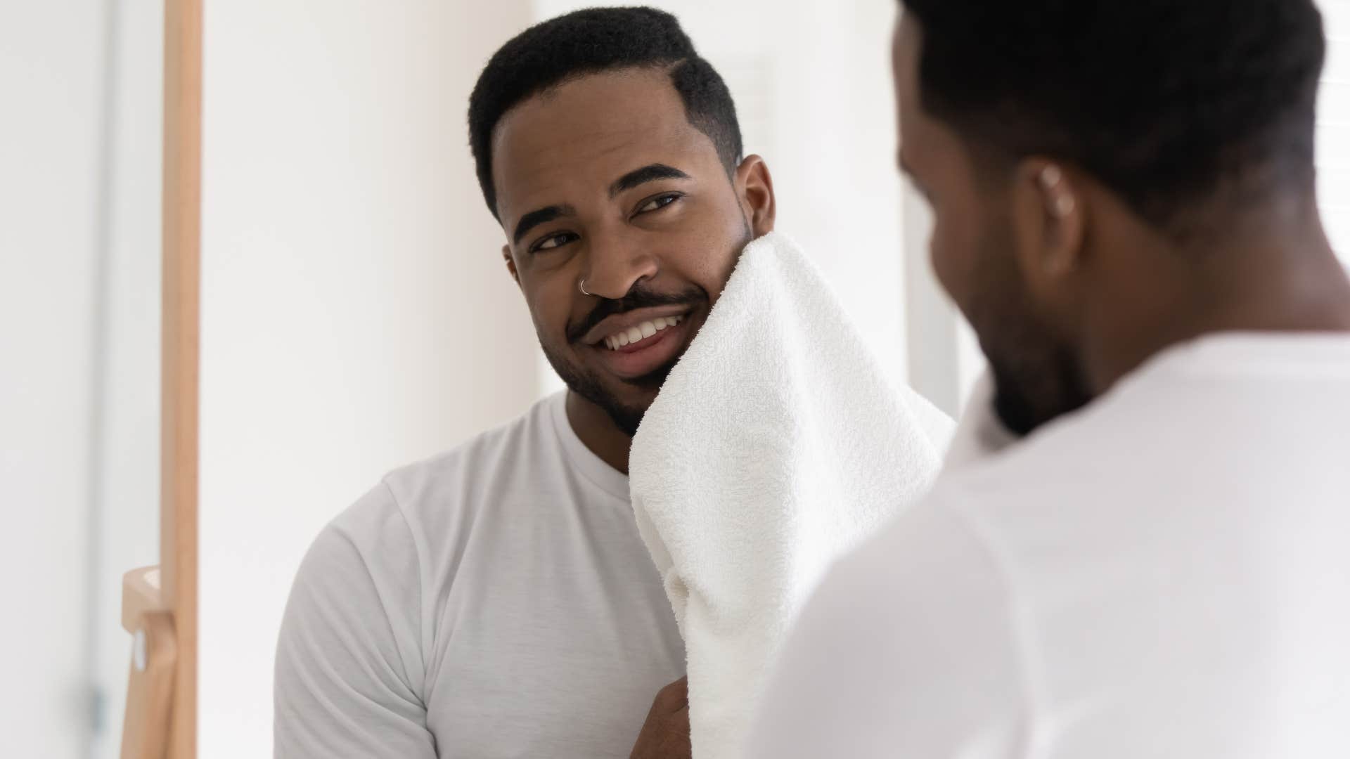 man cleaning his face with clean towel