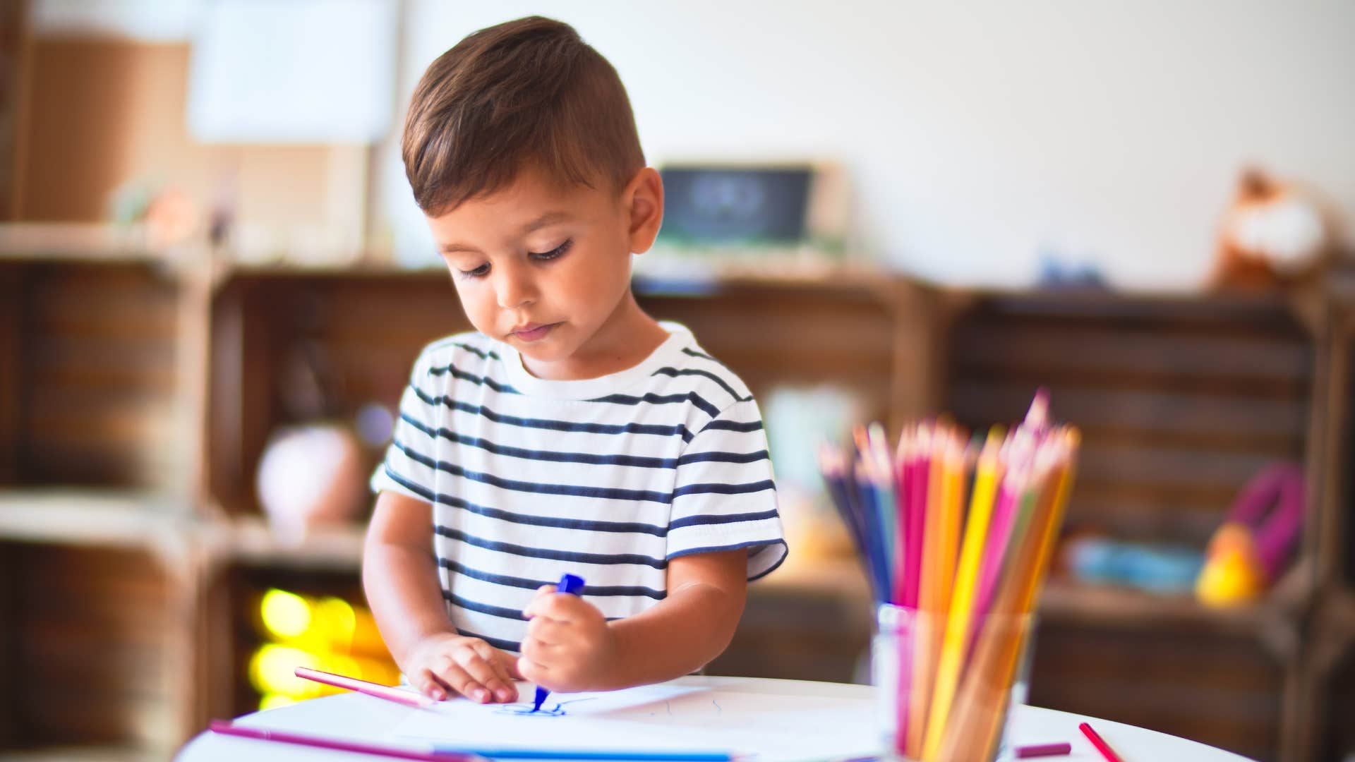 a little boy colors in his home thanks to his parents having art supplies