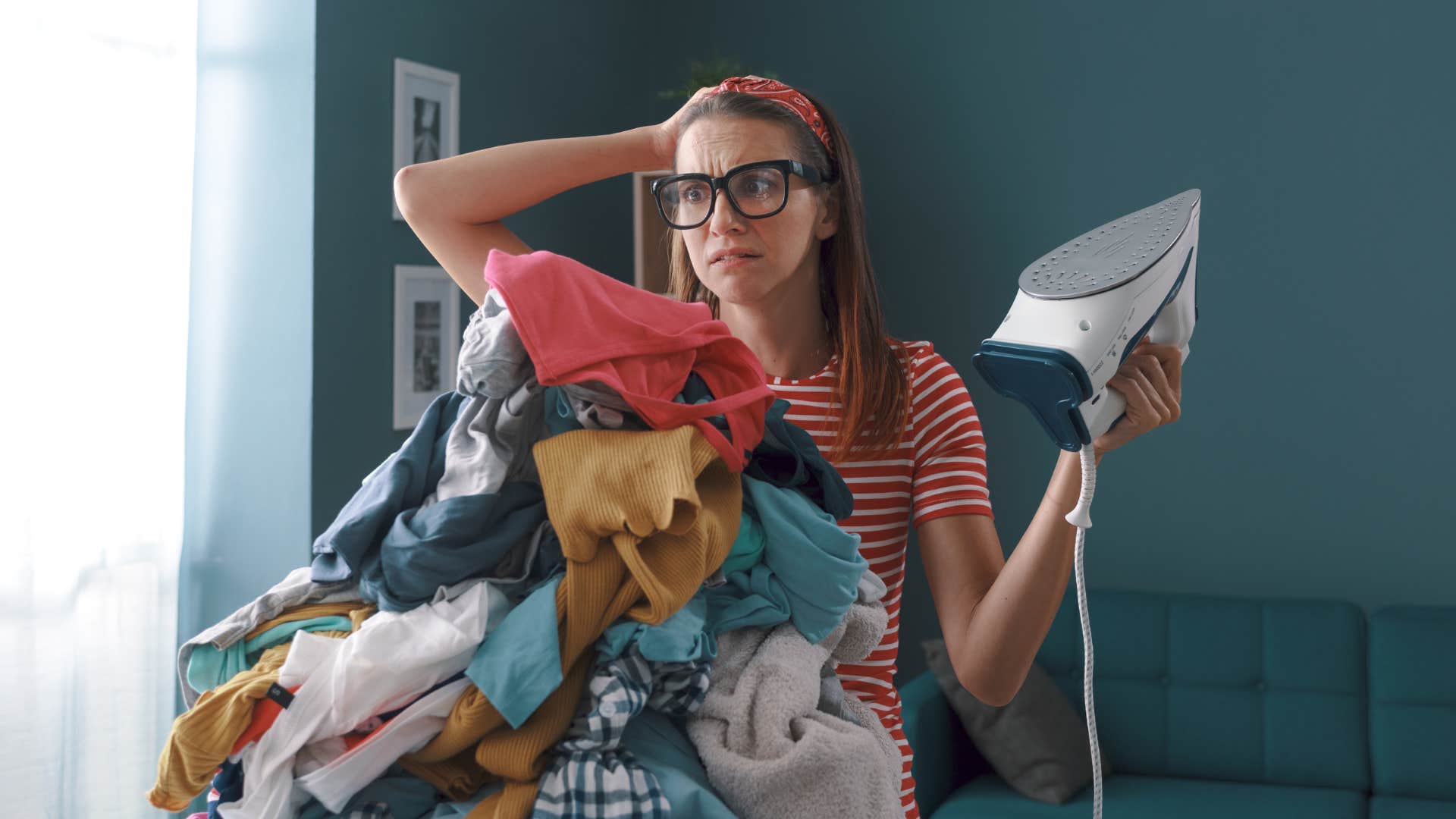 overwhelmed woman trying to iron clothes