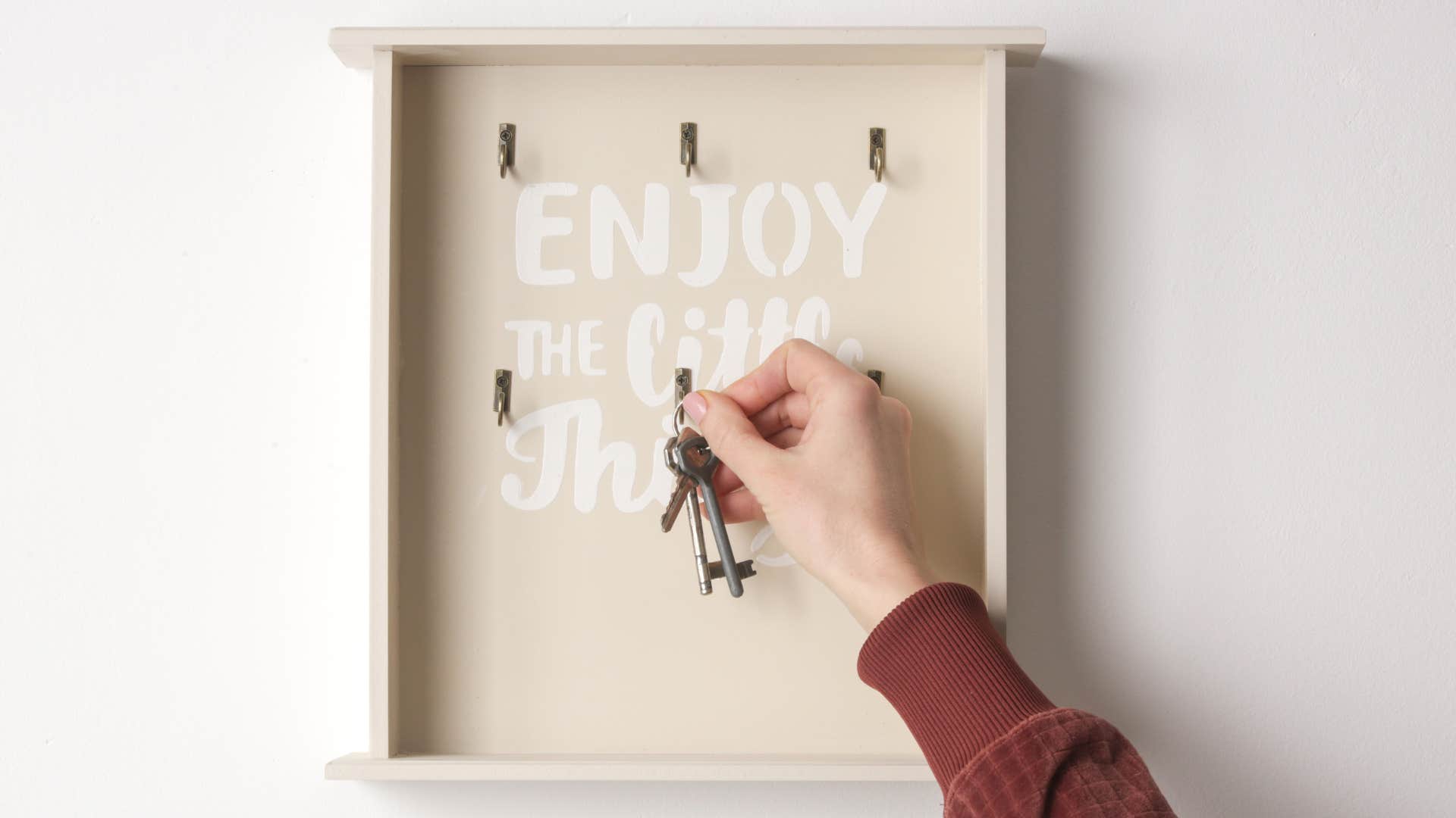 woman hanging her keys on a key organizer