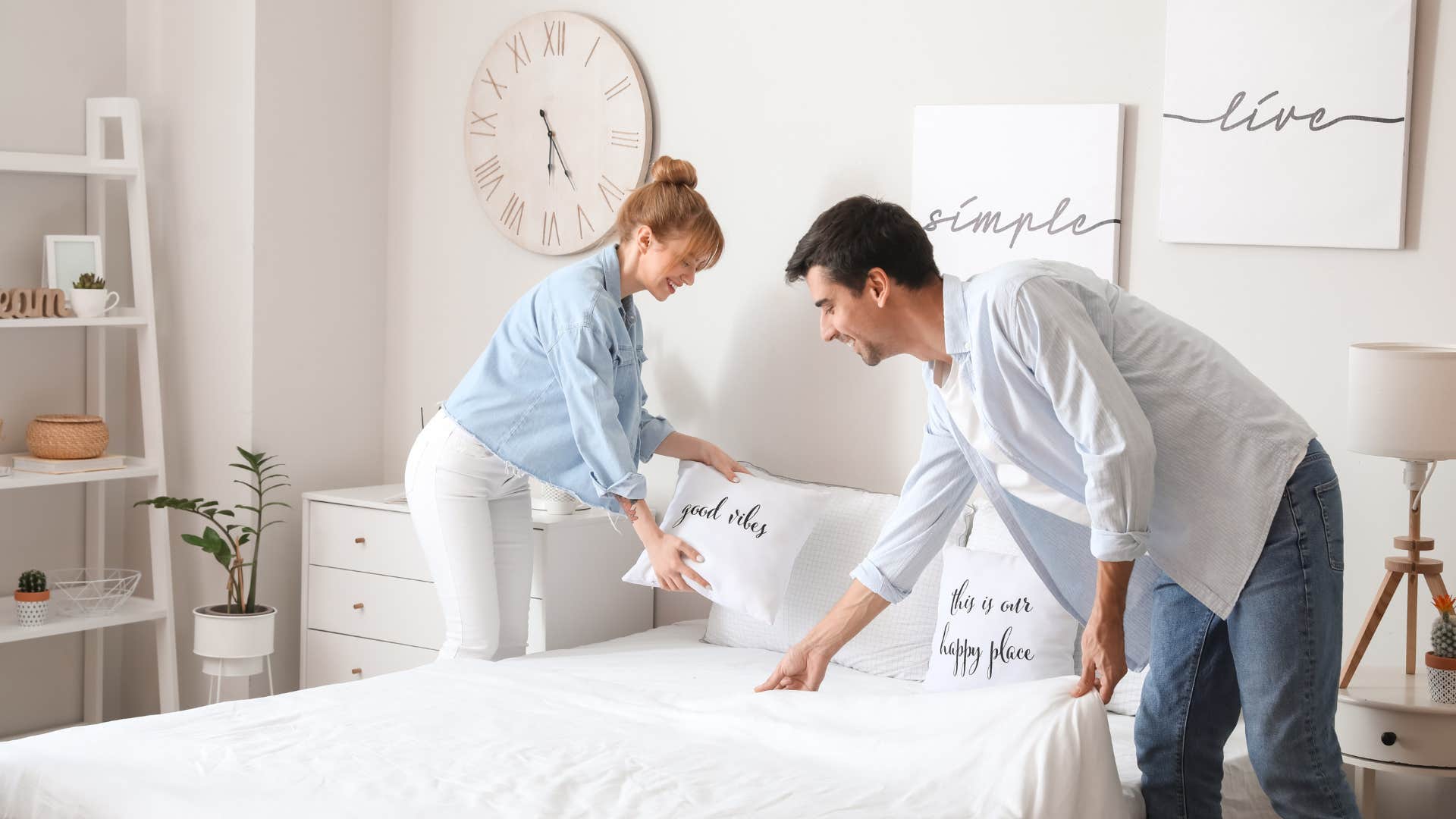 couple putting new set of sheets on the bed