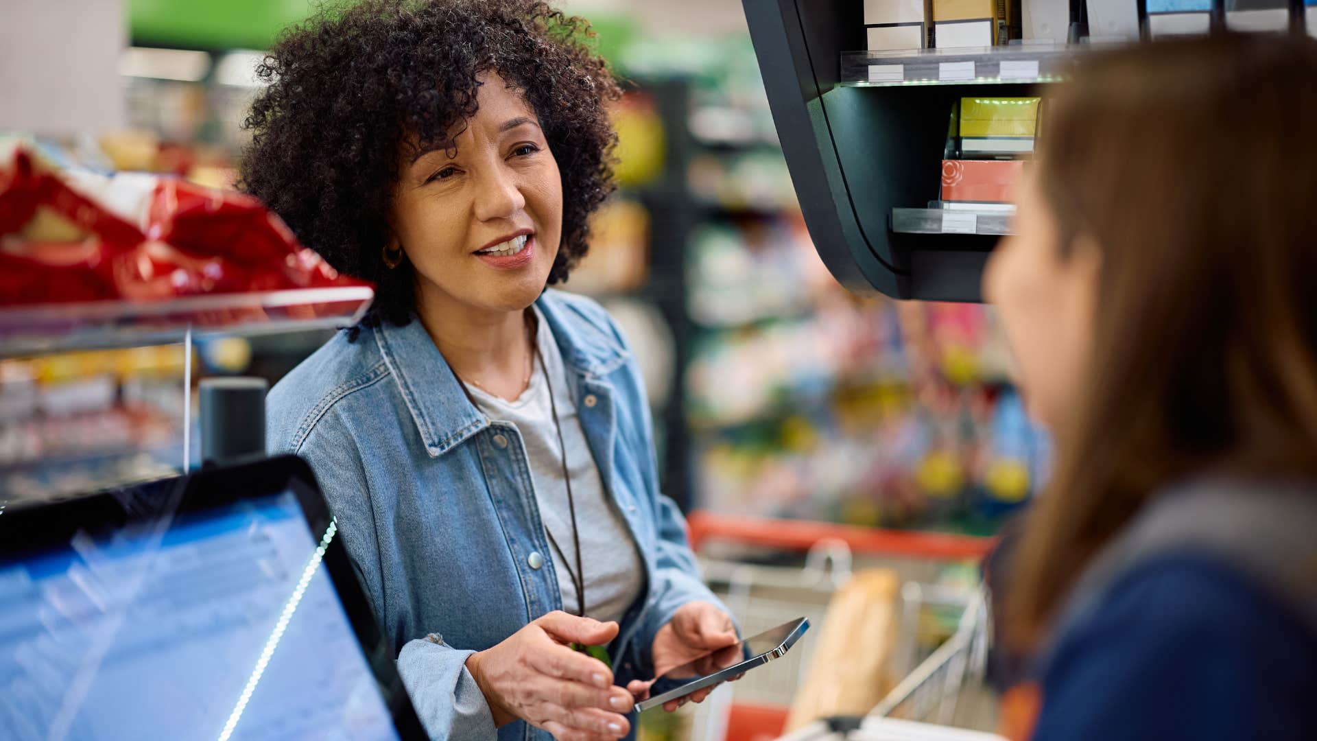 woman at the grocery store checkout talking to a worker