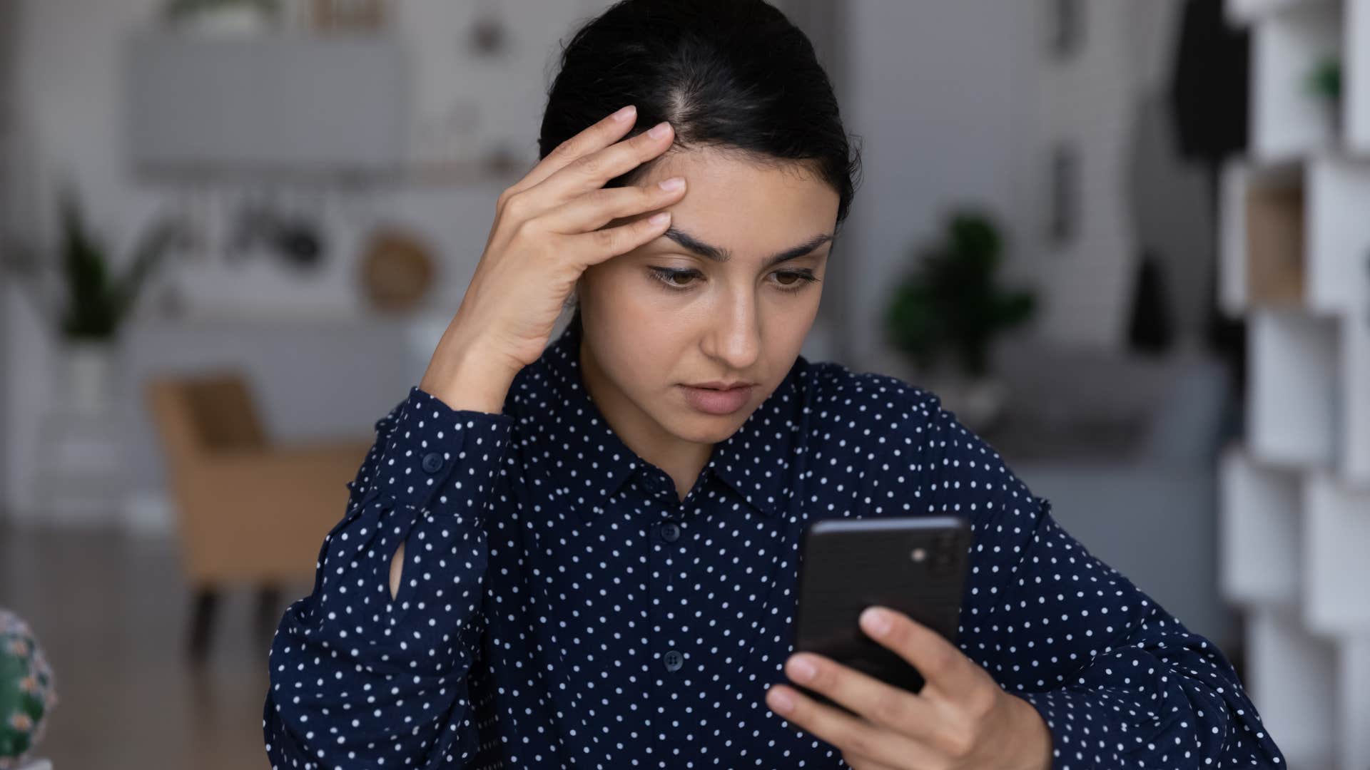 woman subtly checking their bank account at home