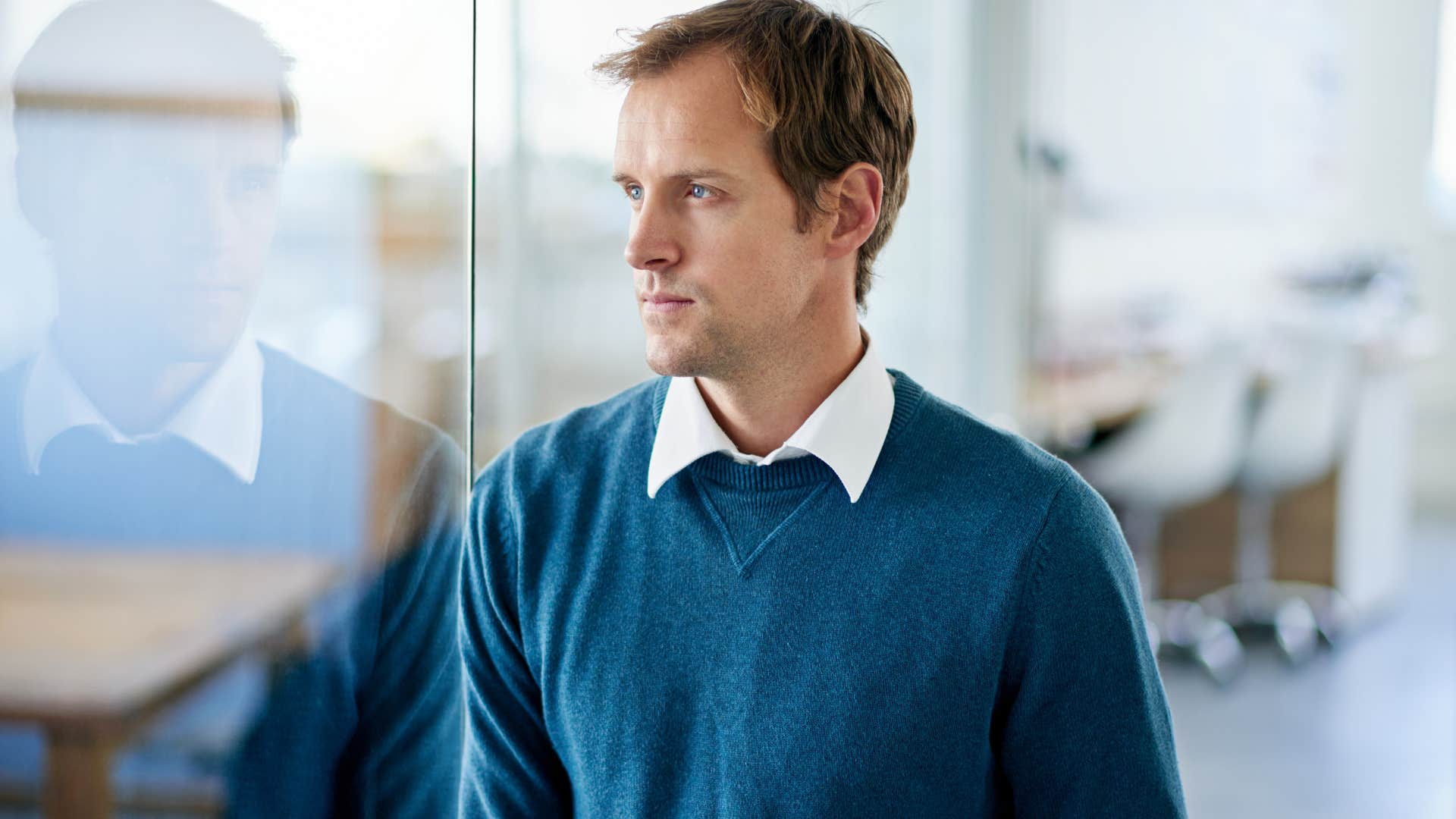 man in blue shirt having unresolved trust issues as he stares off into space