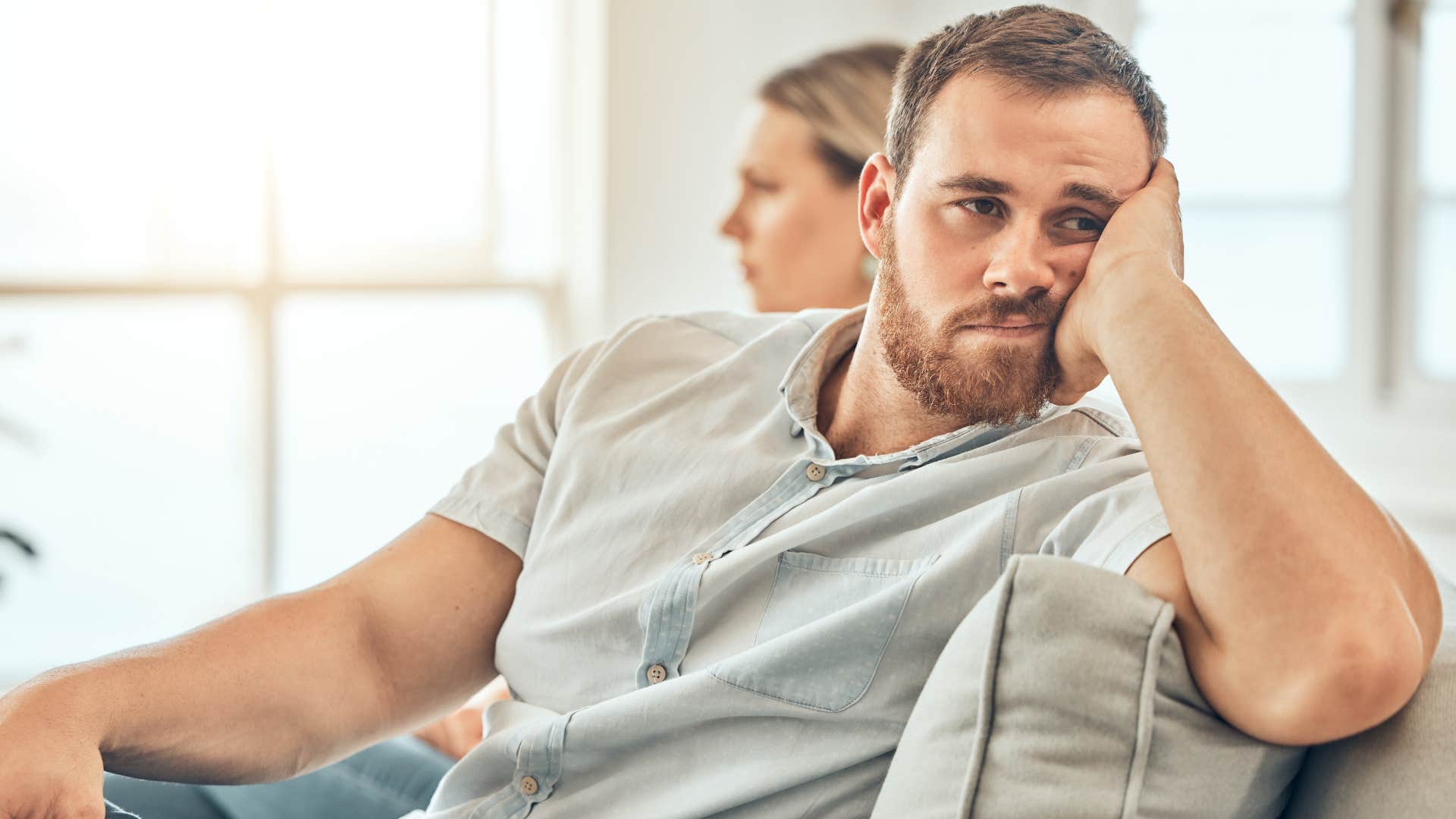 Man with a lack of physical intimacy turned away from his wife.