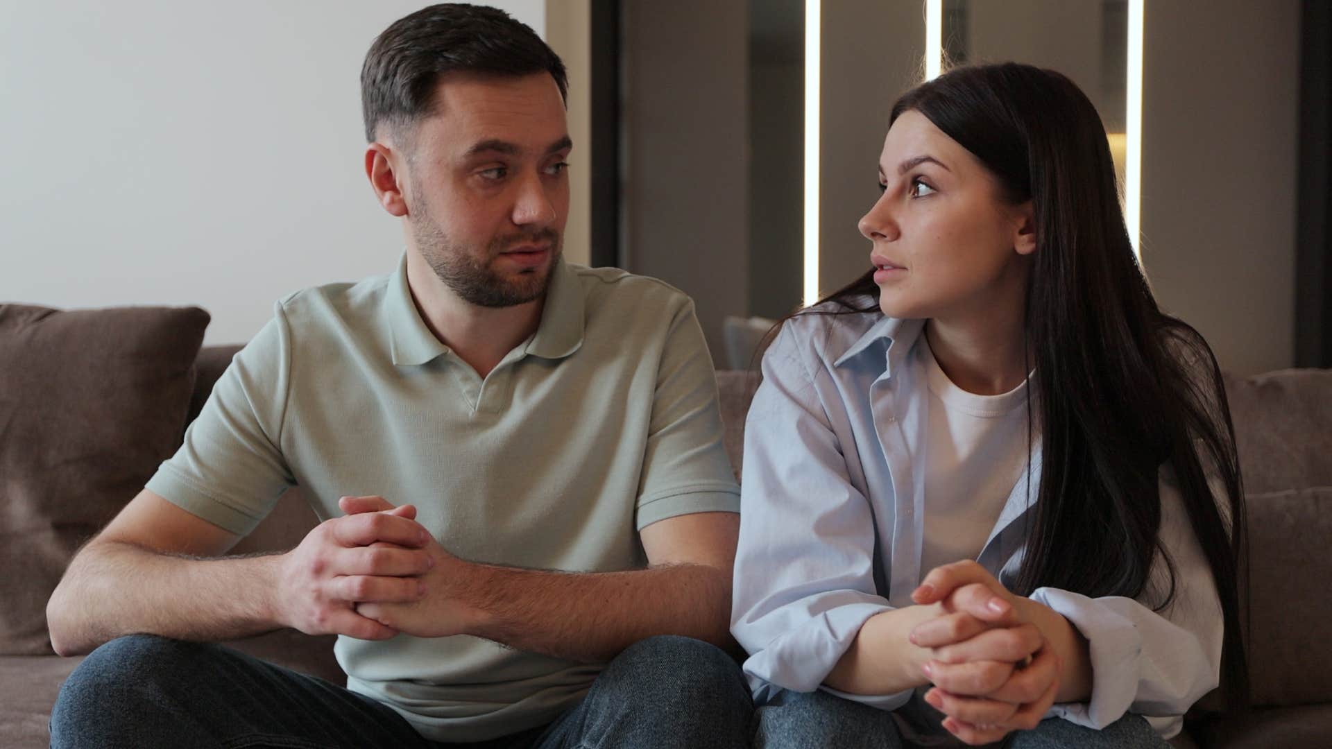 Couple that never has quality time together sitting on a couch.