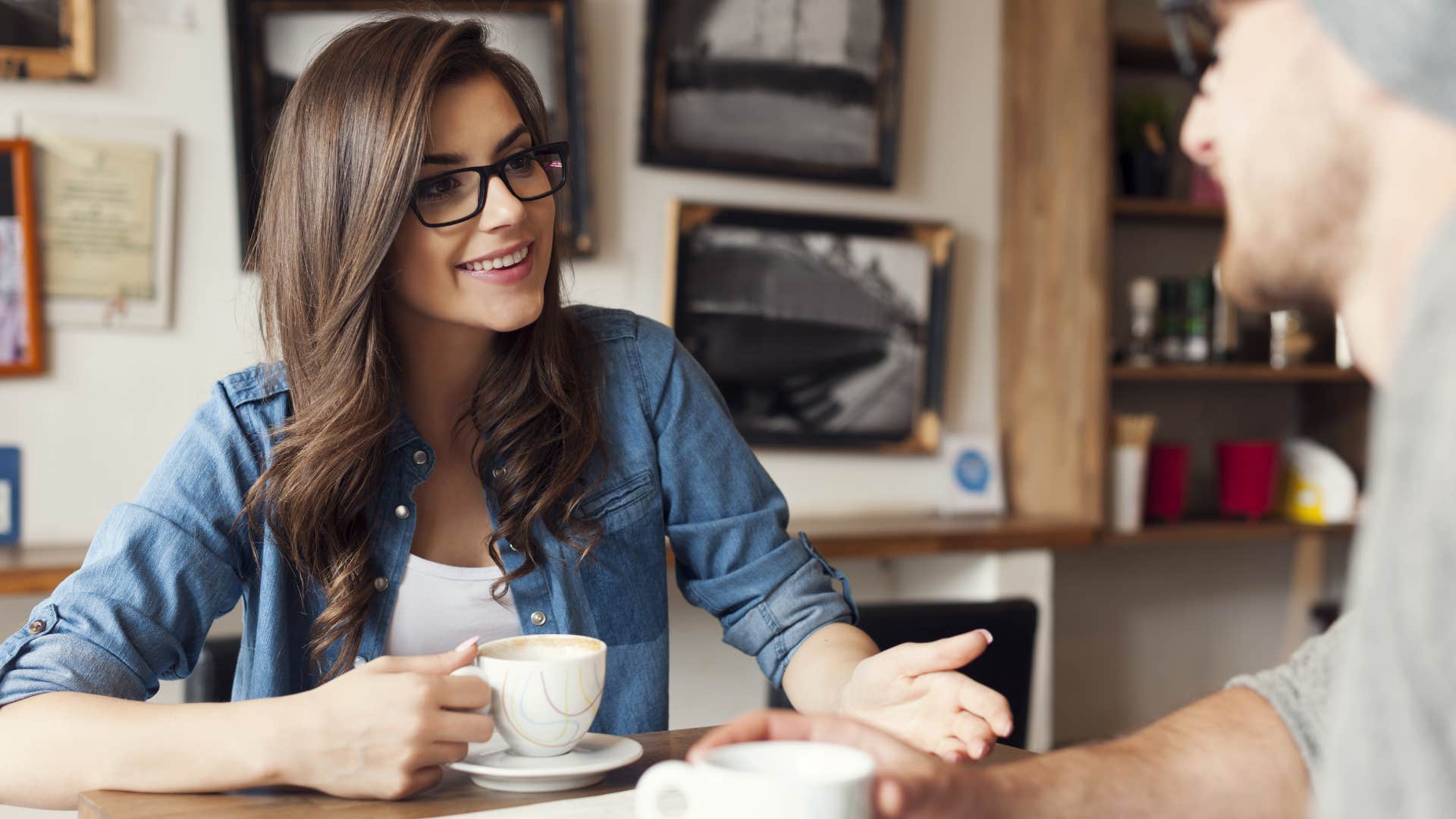 woman in blue jacket and white shirt putting her phone away during conversations and talking to man in gray