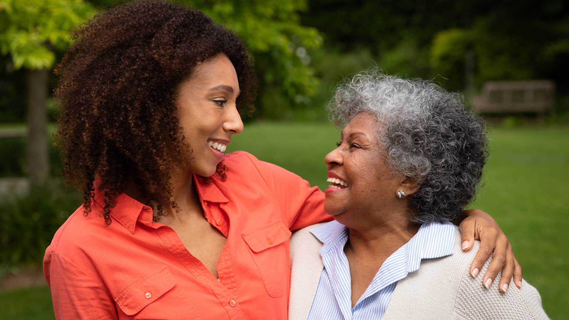 Adult daughter and mother who have a similar personality smiling at each other.
