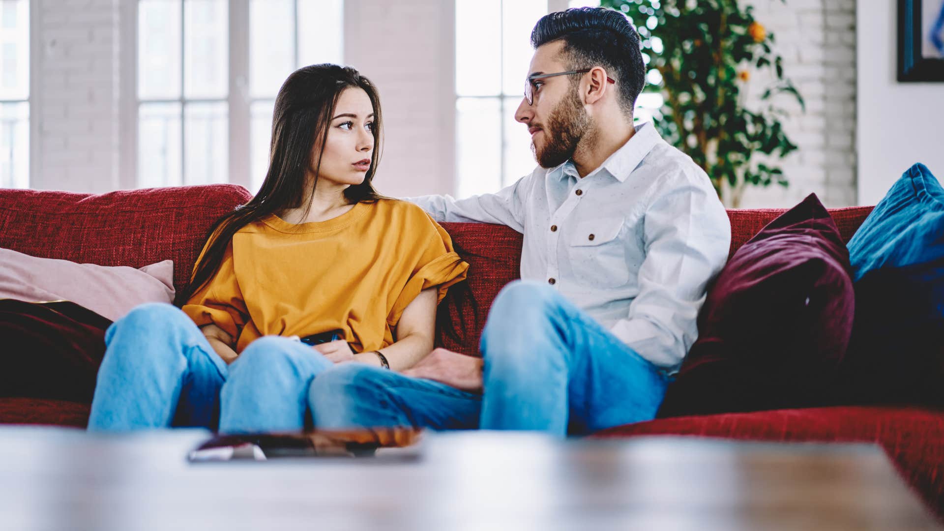 couple stopped romanticizing potential as they have a conversation on the couch