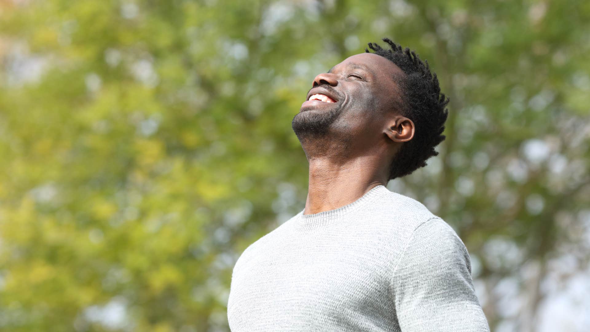 man in white shirt deep breathing outside as he fiercely protects his peace