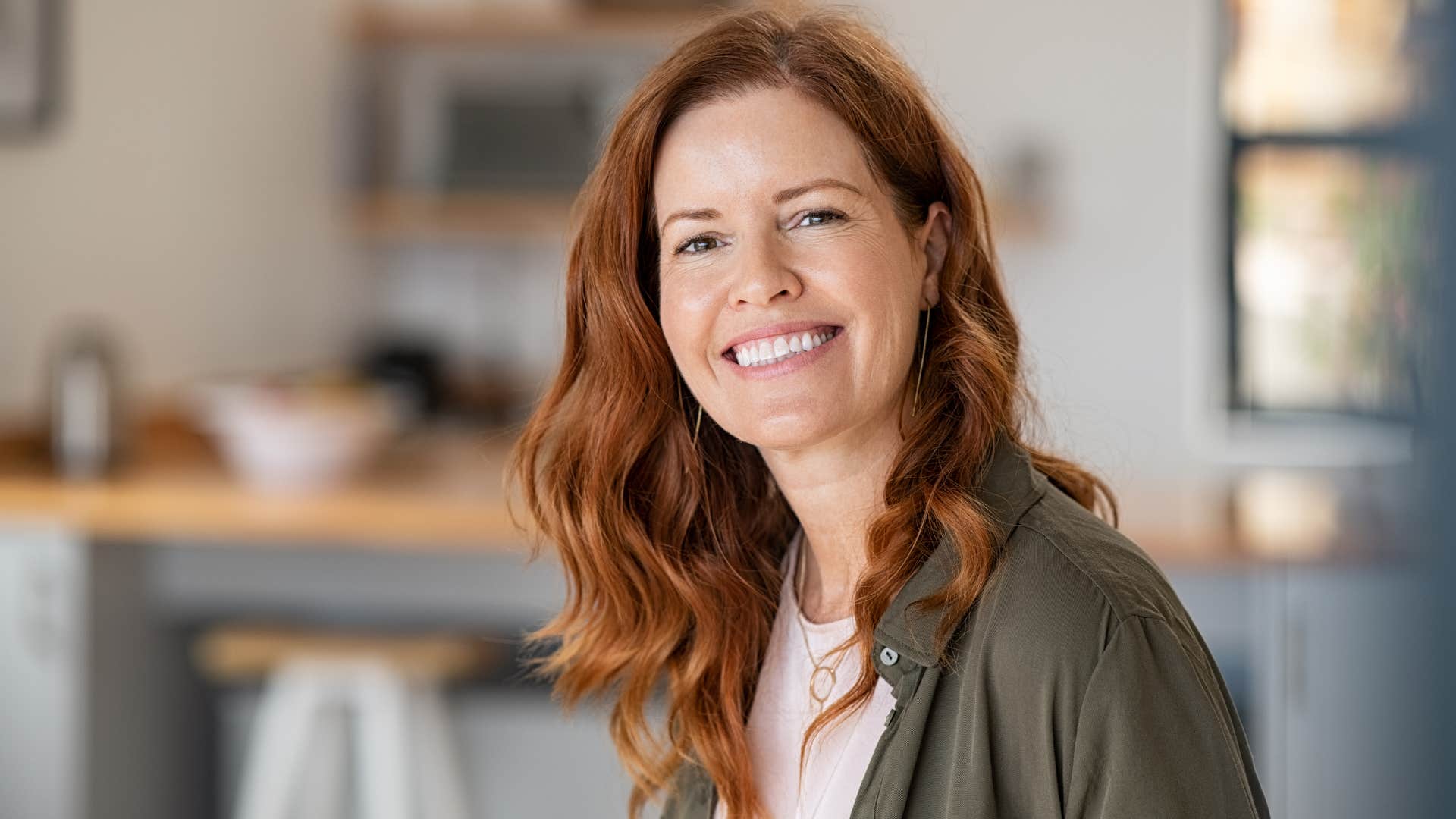 woman in blue cardigan outgrows everyone around her as she smiles happily at camera