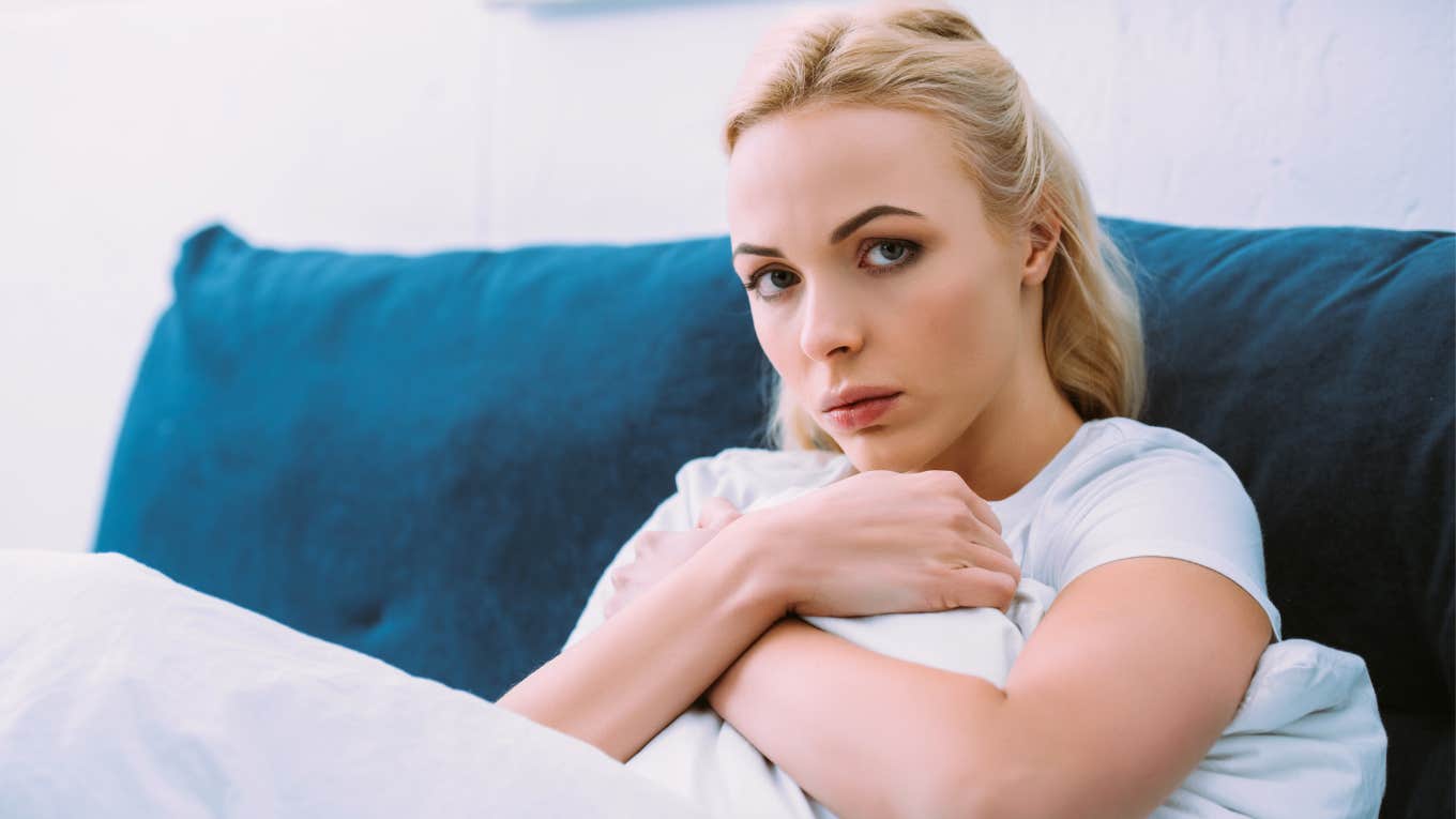 broke woman sitting on couch looking stressed