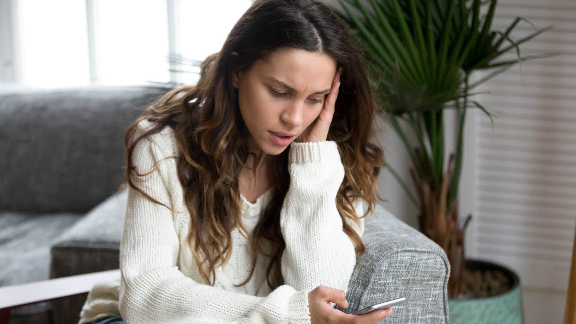 sad woman texting I'll just sit this one out on her phone