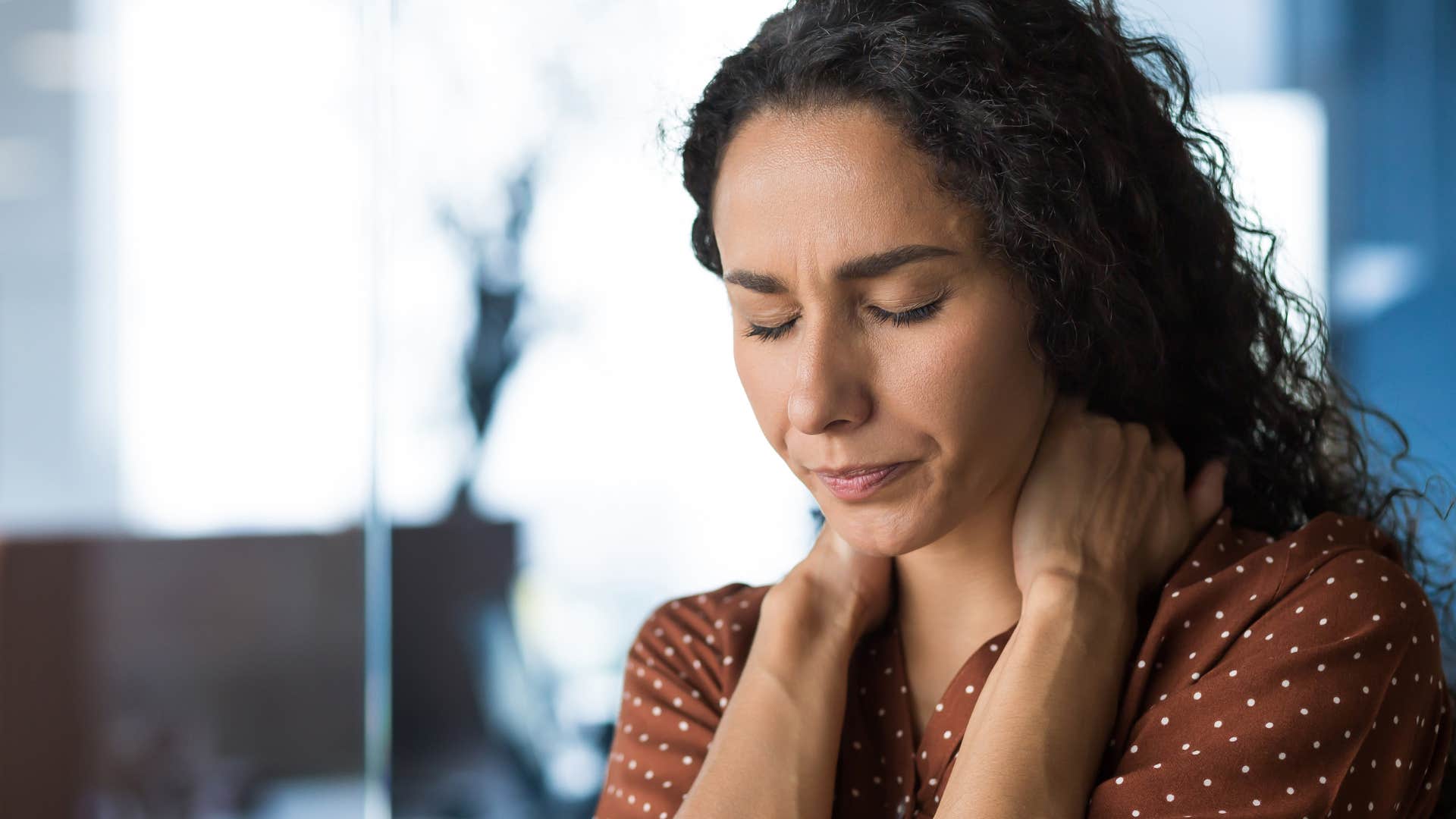 woman feeling stressed rubbing neck