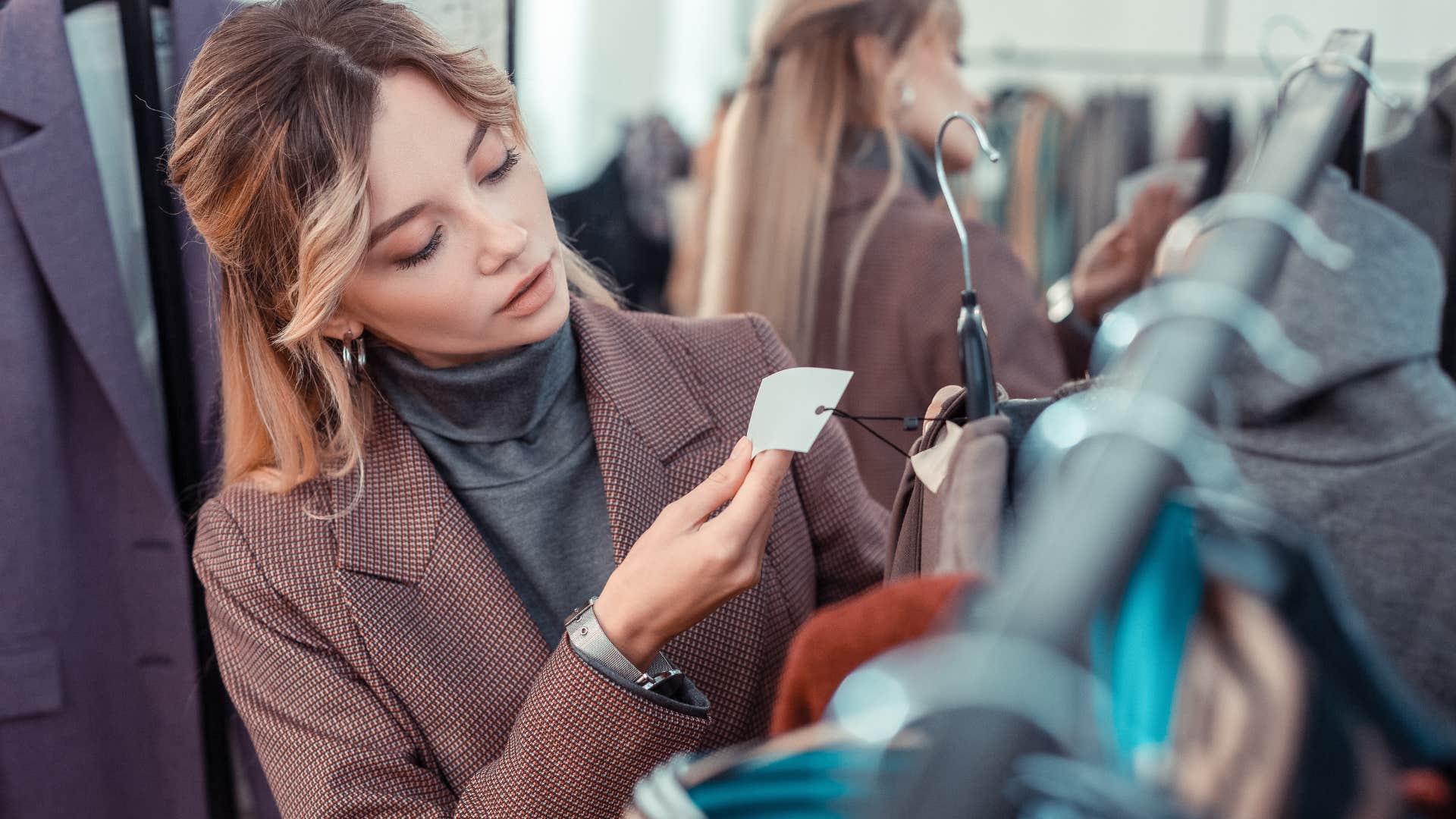 woman looking at price tag on clothes