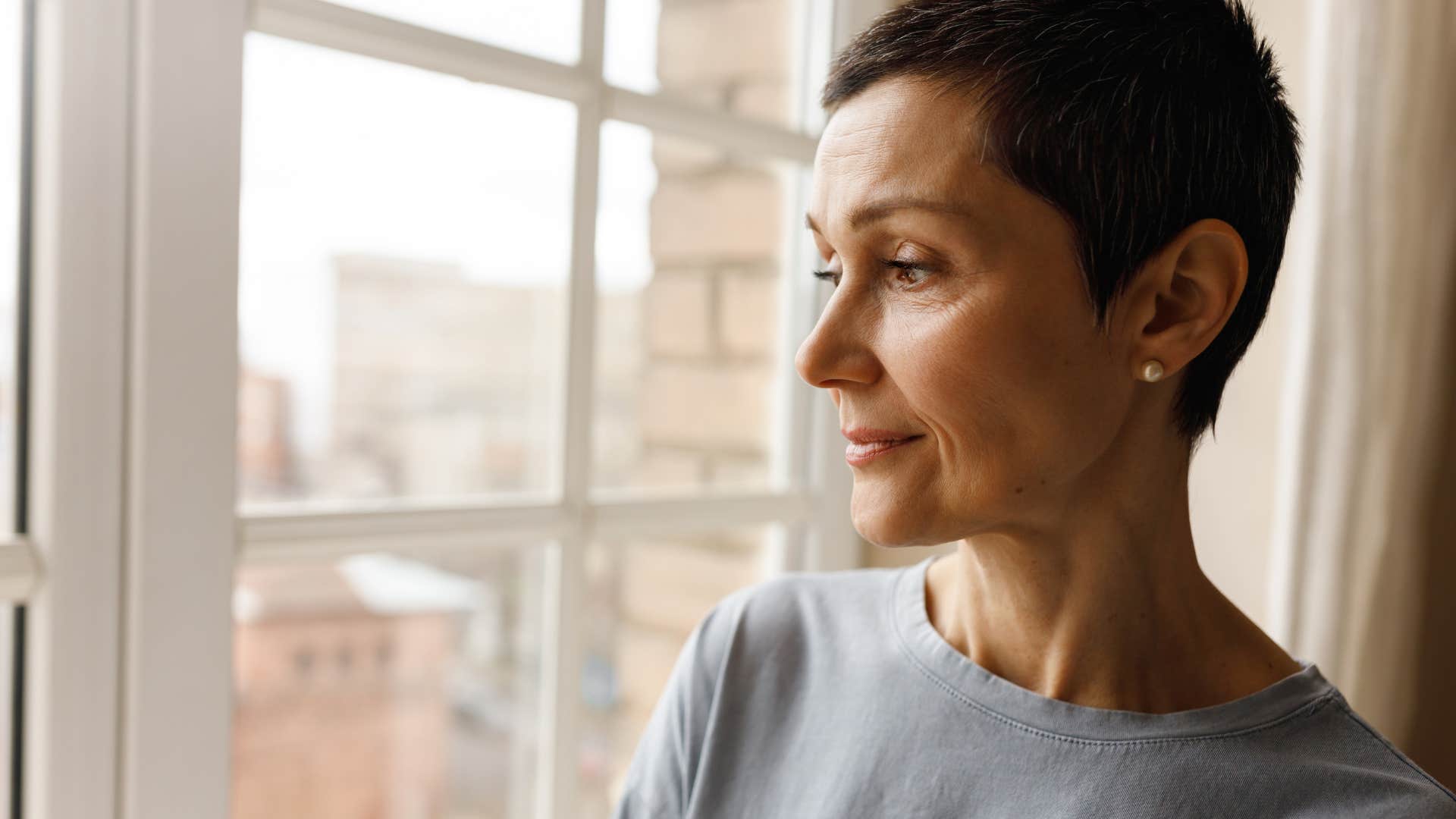 Woman who doesn't appreciate conformity looking out a window.