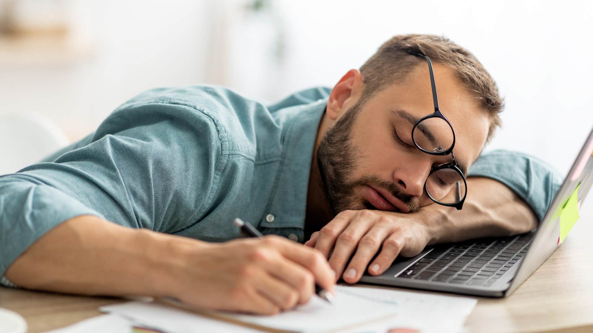 Man who's burnt out from work sleeping on his laptop.