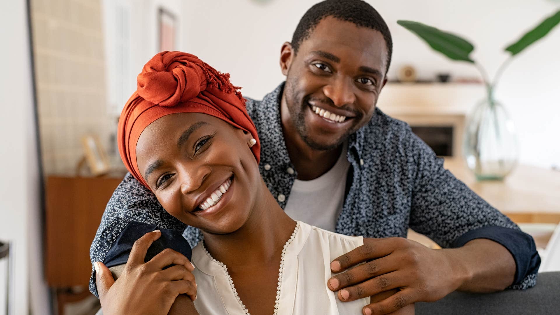 Woman with healthy relationships at home hugging her partner.