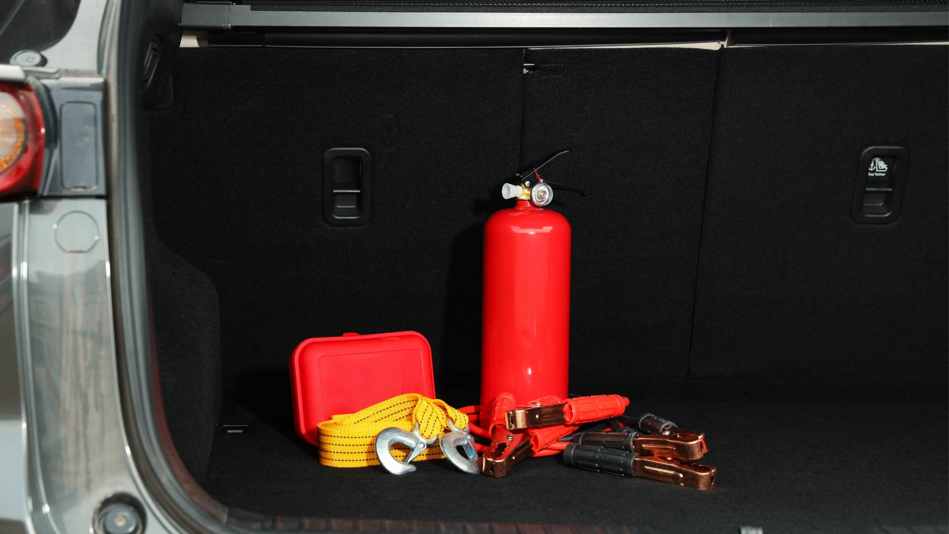 a close up of emergency tools and kits in the trunk of a car