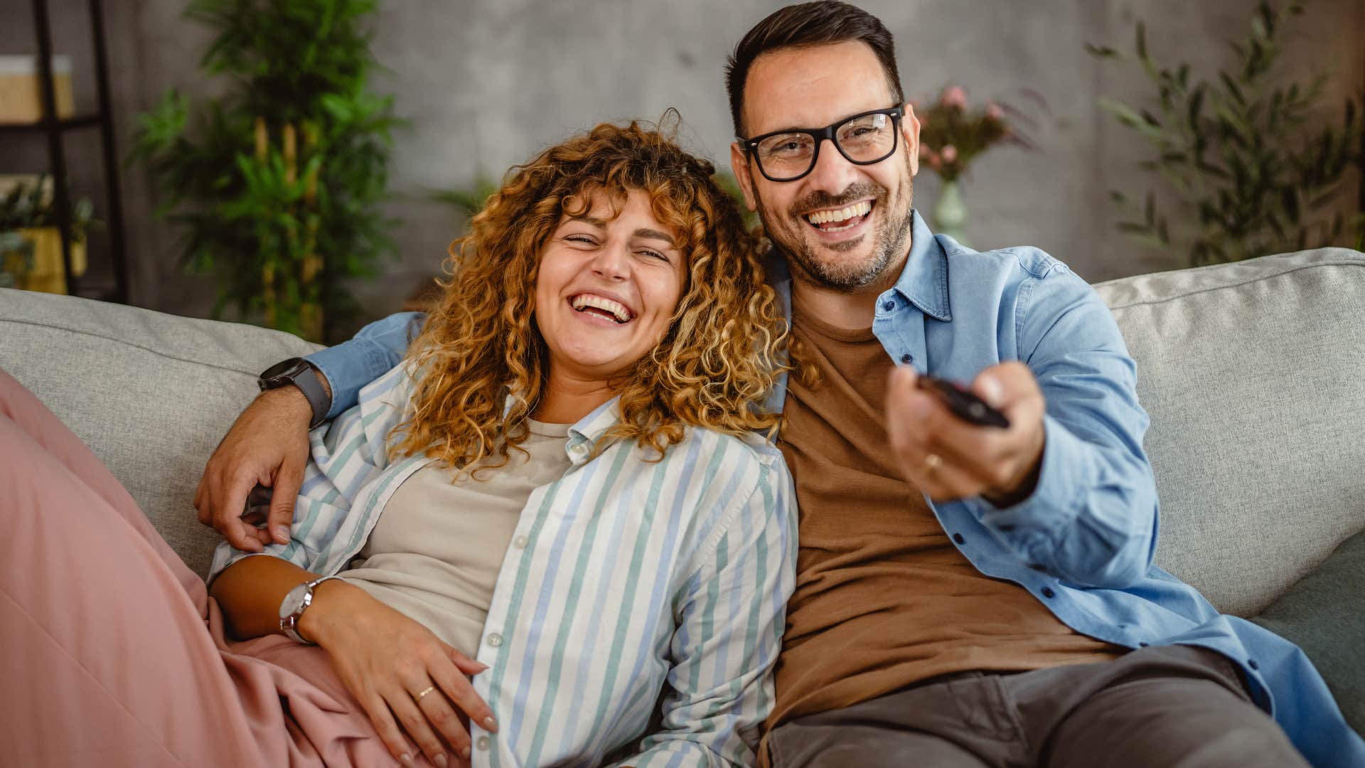Couple smiling and sitting in a comfortable shared space.