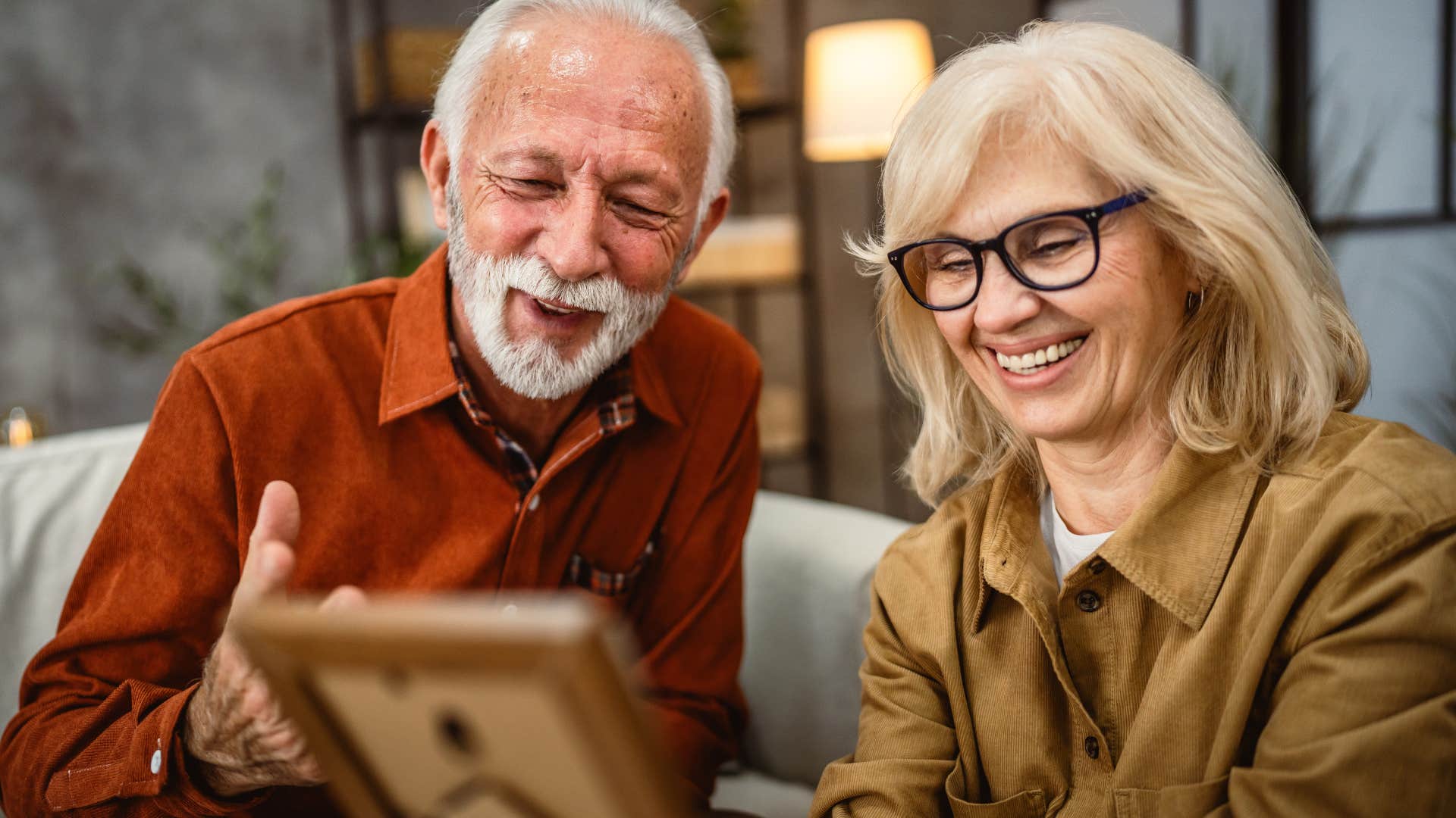 Happy couple looking at personal photos at home.
