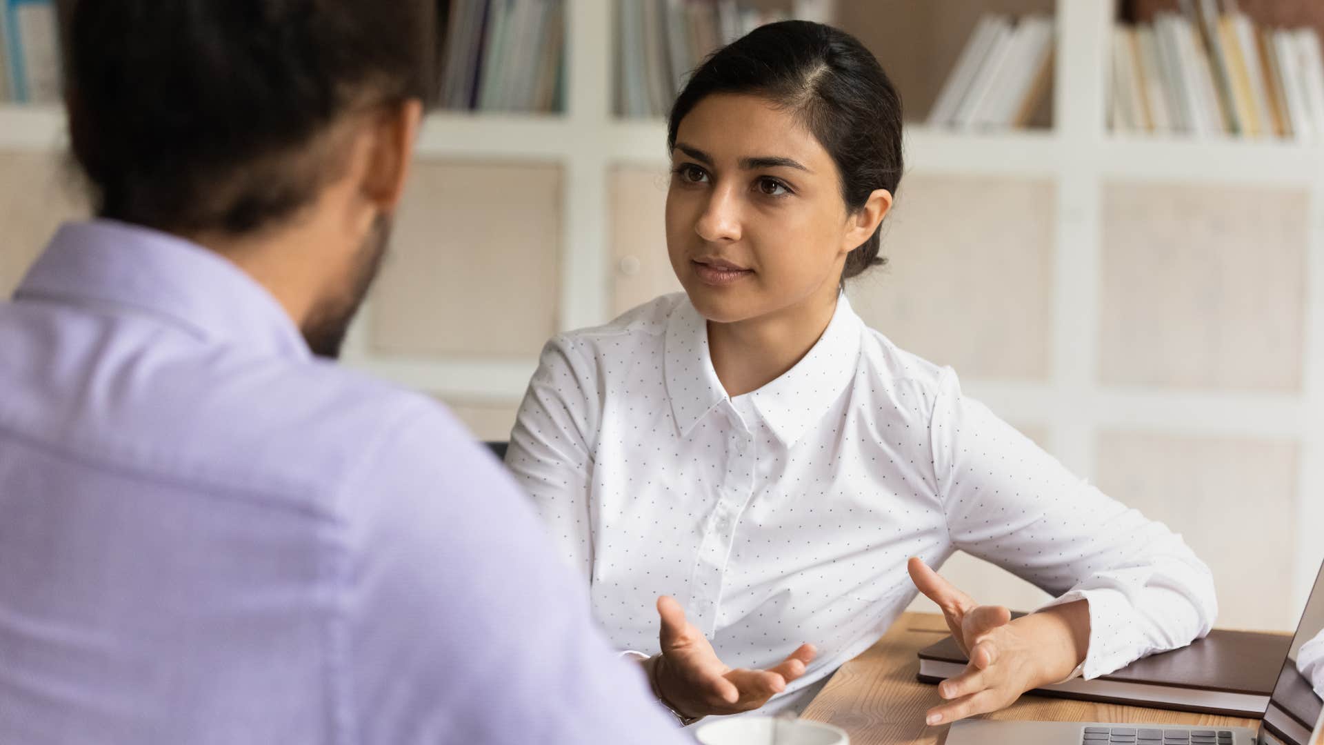 professional woman saying I'm not sure I'm the best person to handle this to a co-worker