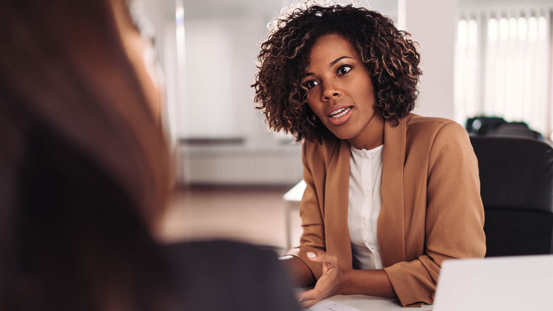 professional woman telling worker I'm happy to help but I don't have time right now