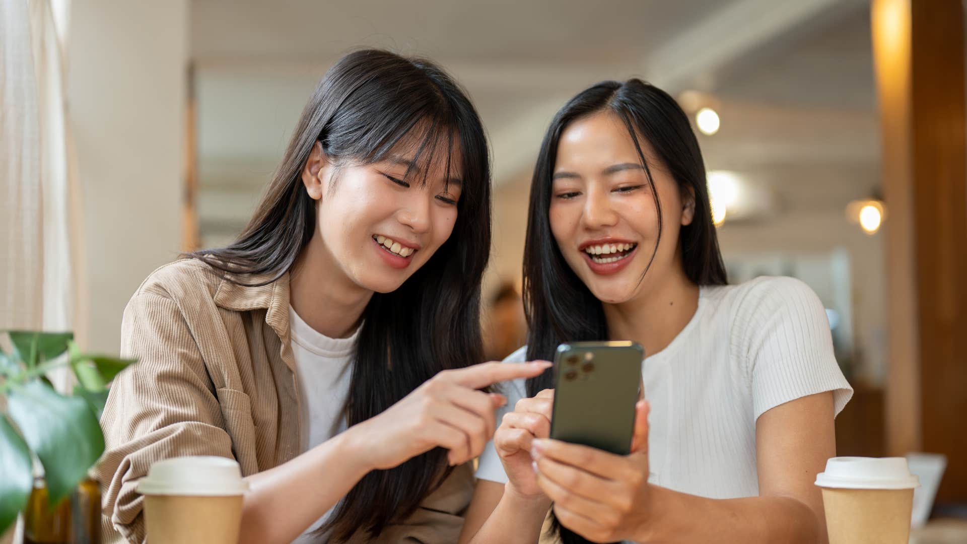 a woman shows her friend her text message thread but her friend gets lost in the conversation