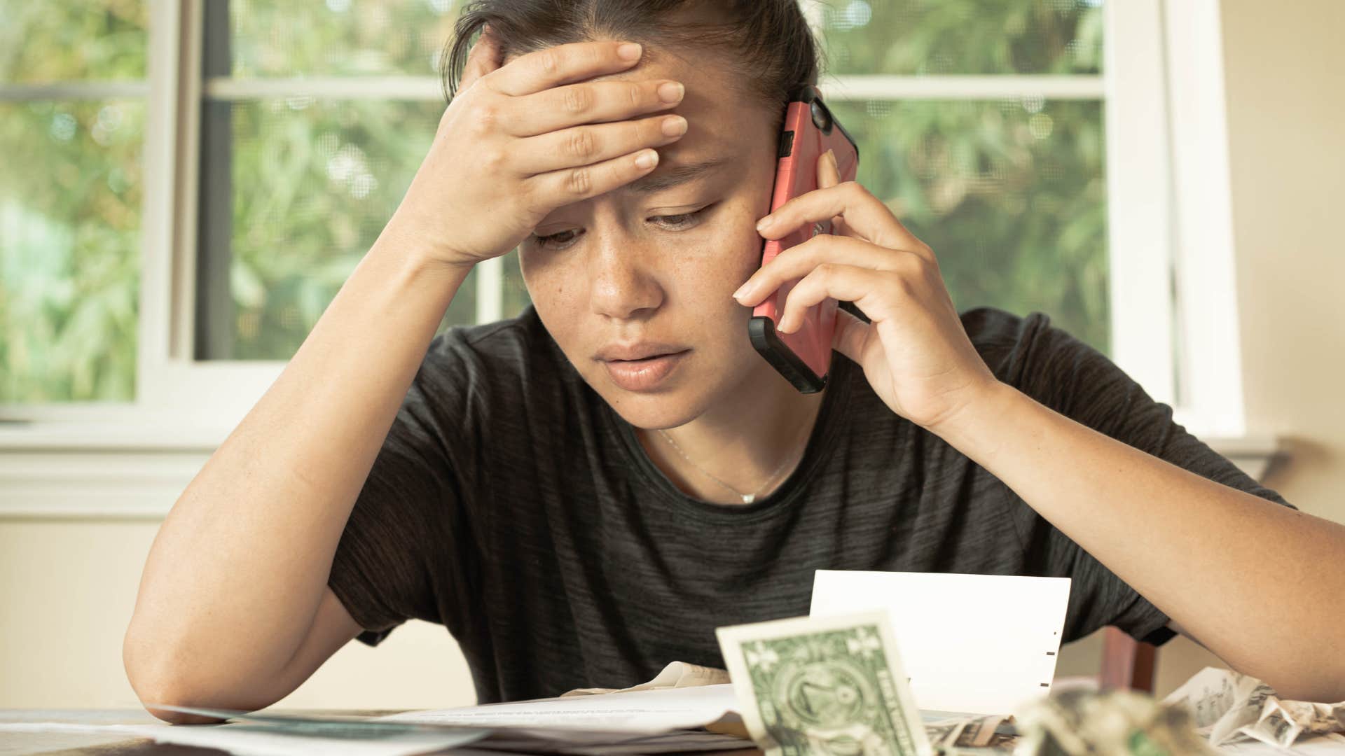 financially stressed woman telling friend she is helping out her family financially