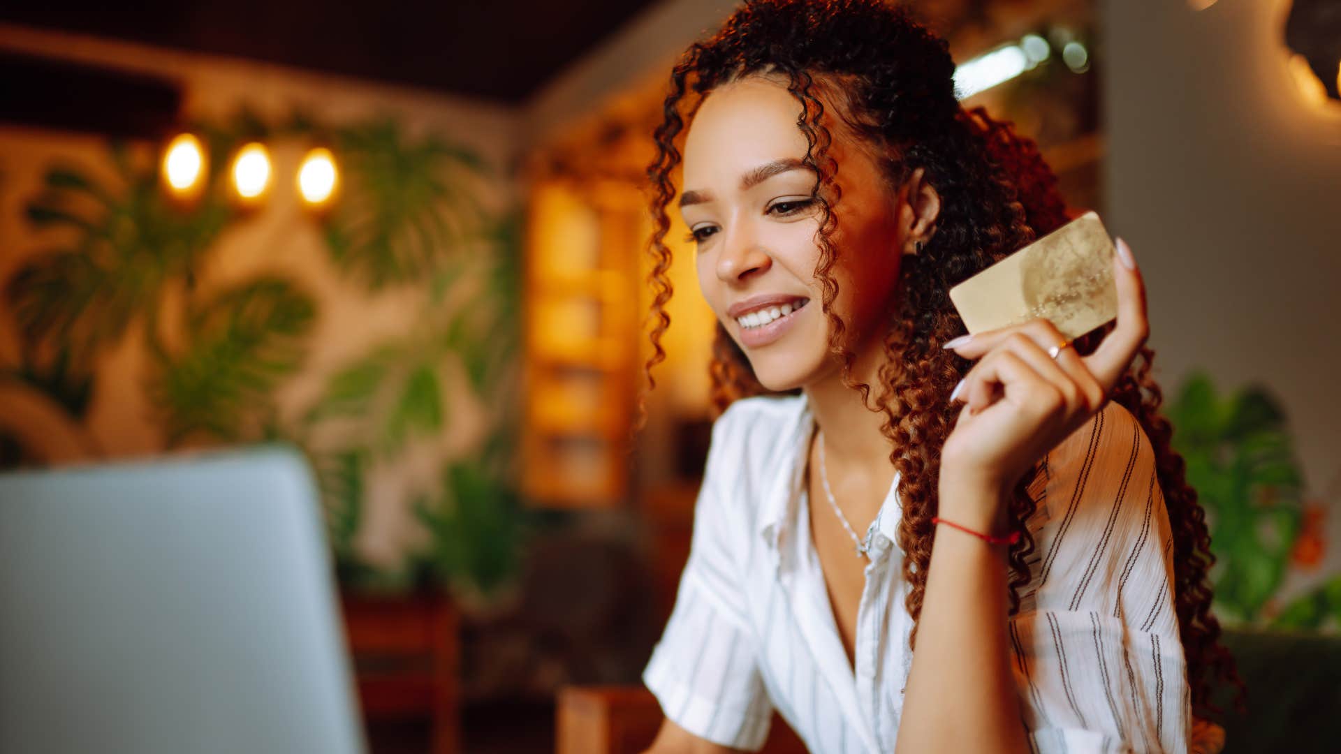 woman holding a credit card saying she doesnt believe in debt